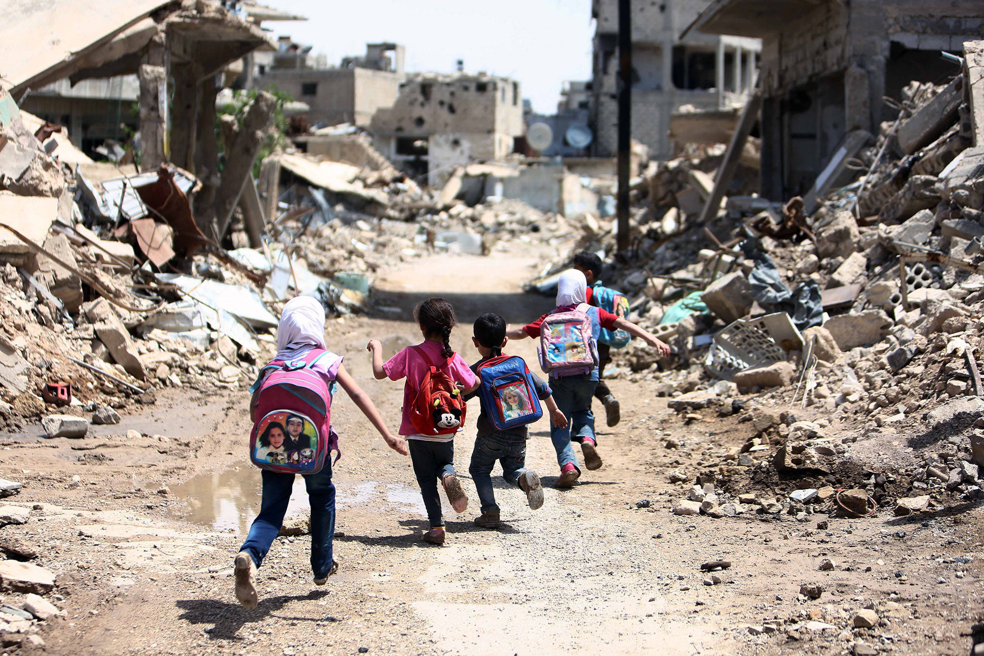 children, colorful backpacks, rubble-strewn streets, Full HD Desktop Wallpaper