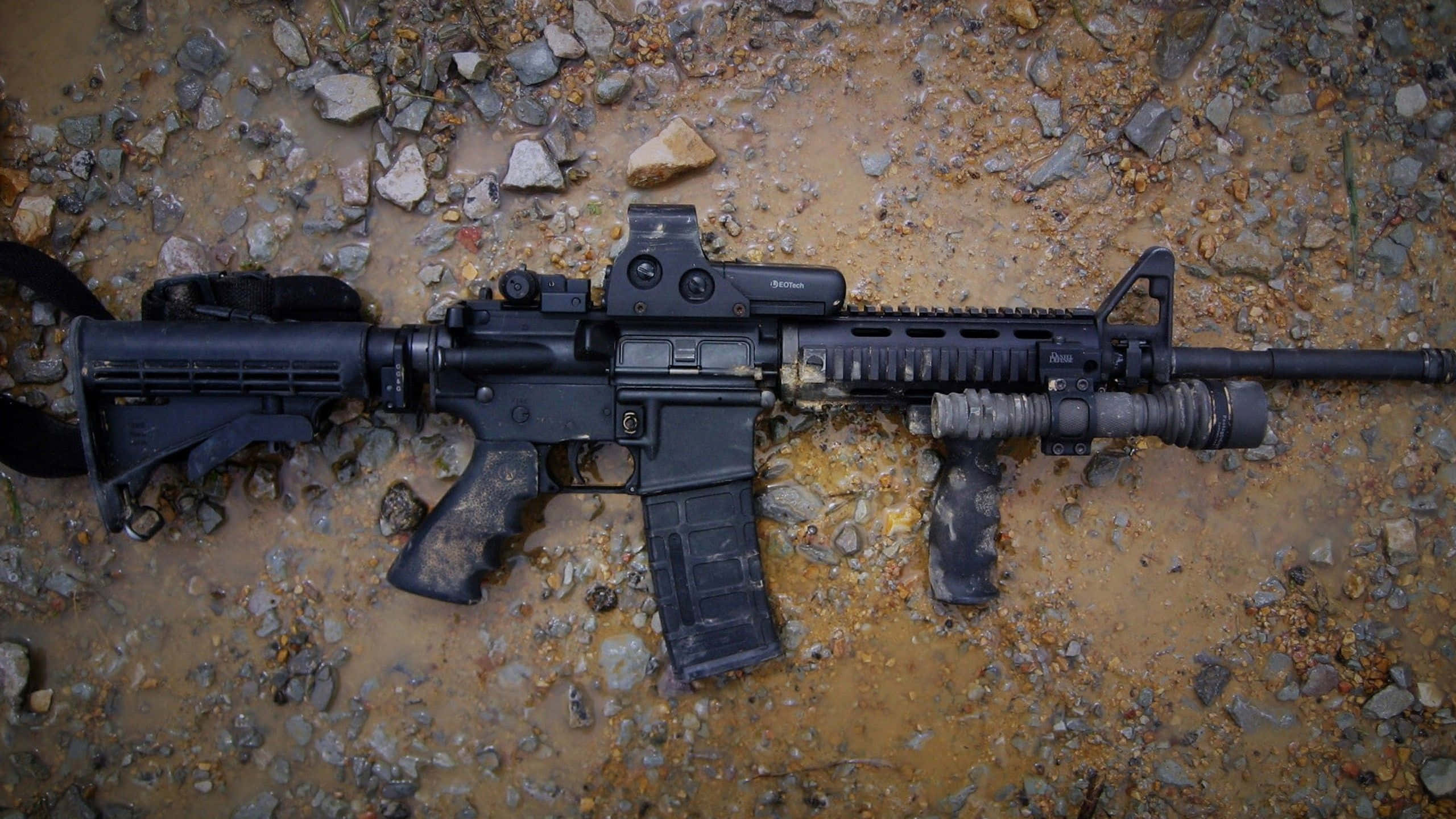 black assault rifle, muddy gravel terrain, natural light, 2K Desktop Wallpaper
