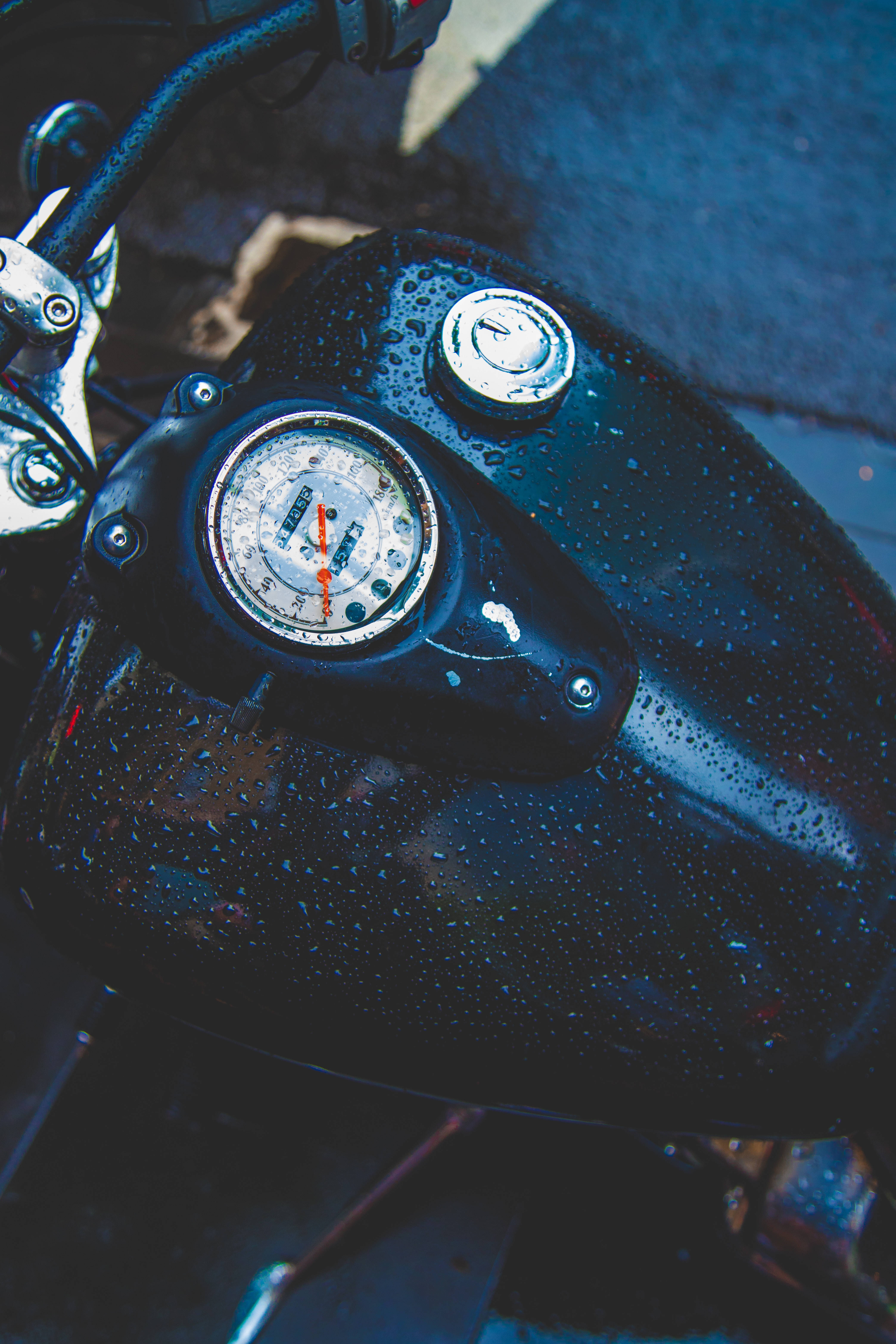 wet black motorcycle fuel tank, vintage gauge, chrome accents, 5K Phone Wallpaper