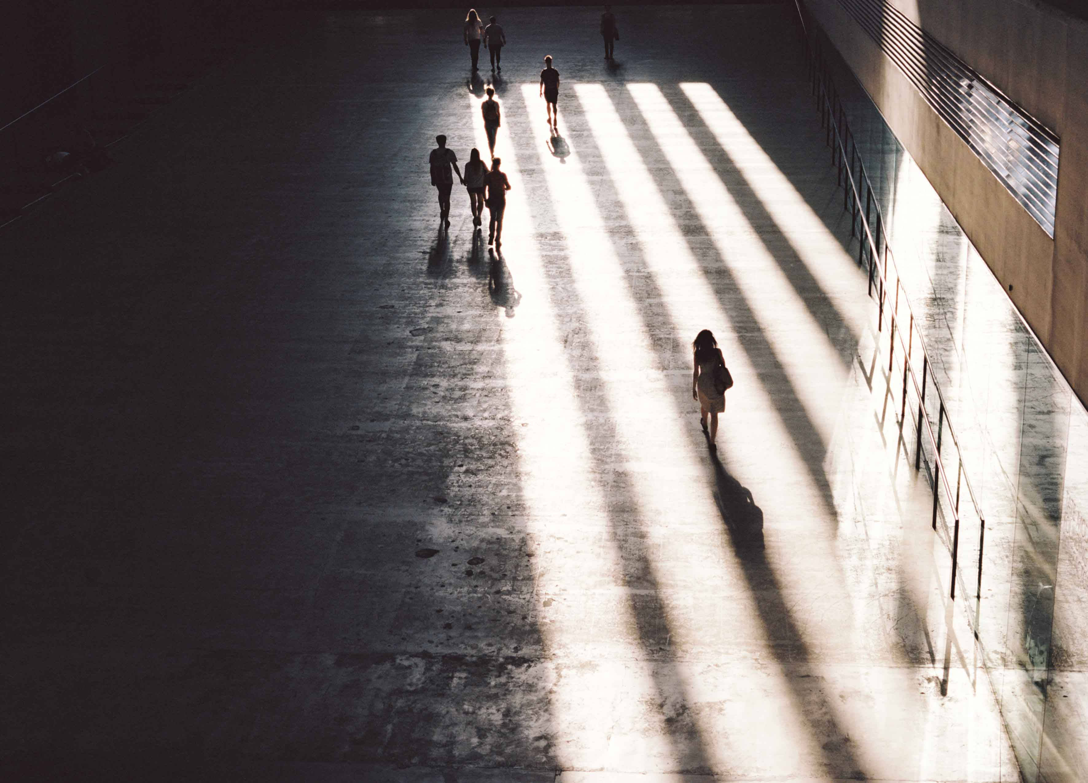Tate Modern, sunlit concrete corridor, silhouetted figures, 2K Desktop Wallpaper
