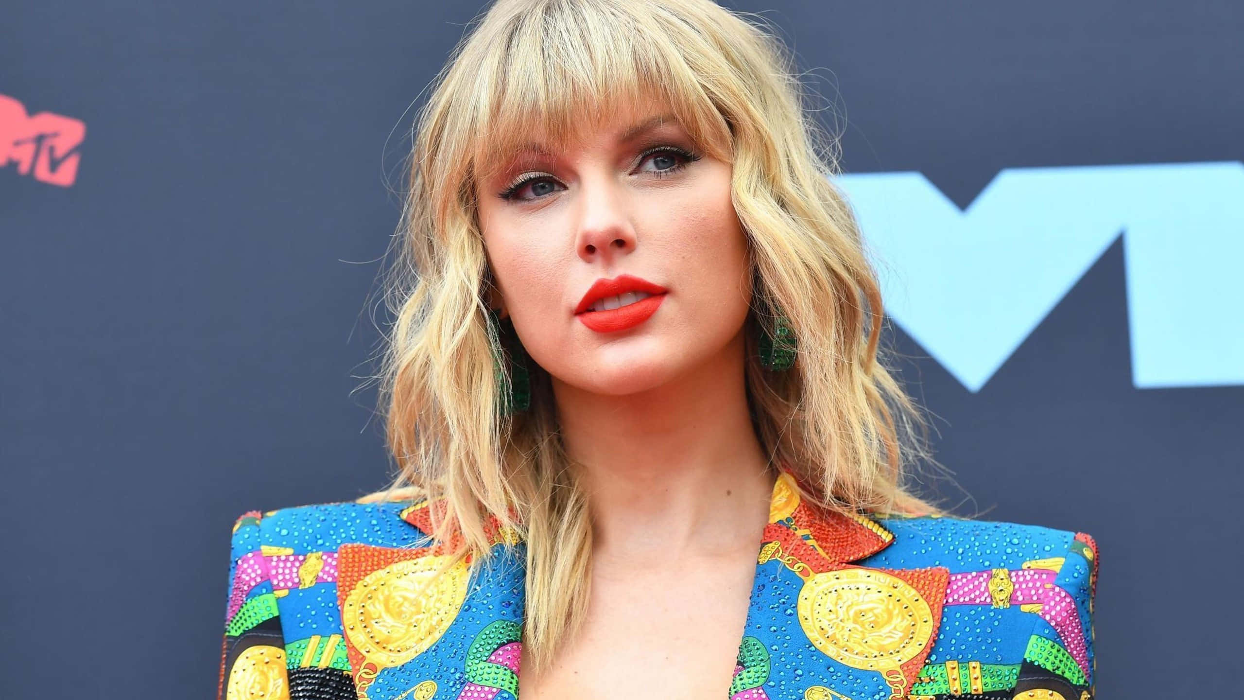 Taylor Swift, vibrant patterned blazer, dark blue MTV backdrop, 2K Desktop Wallpaper
