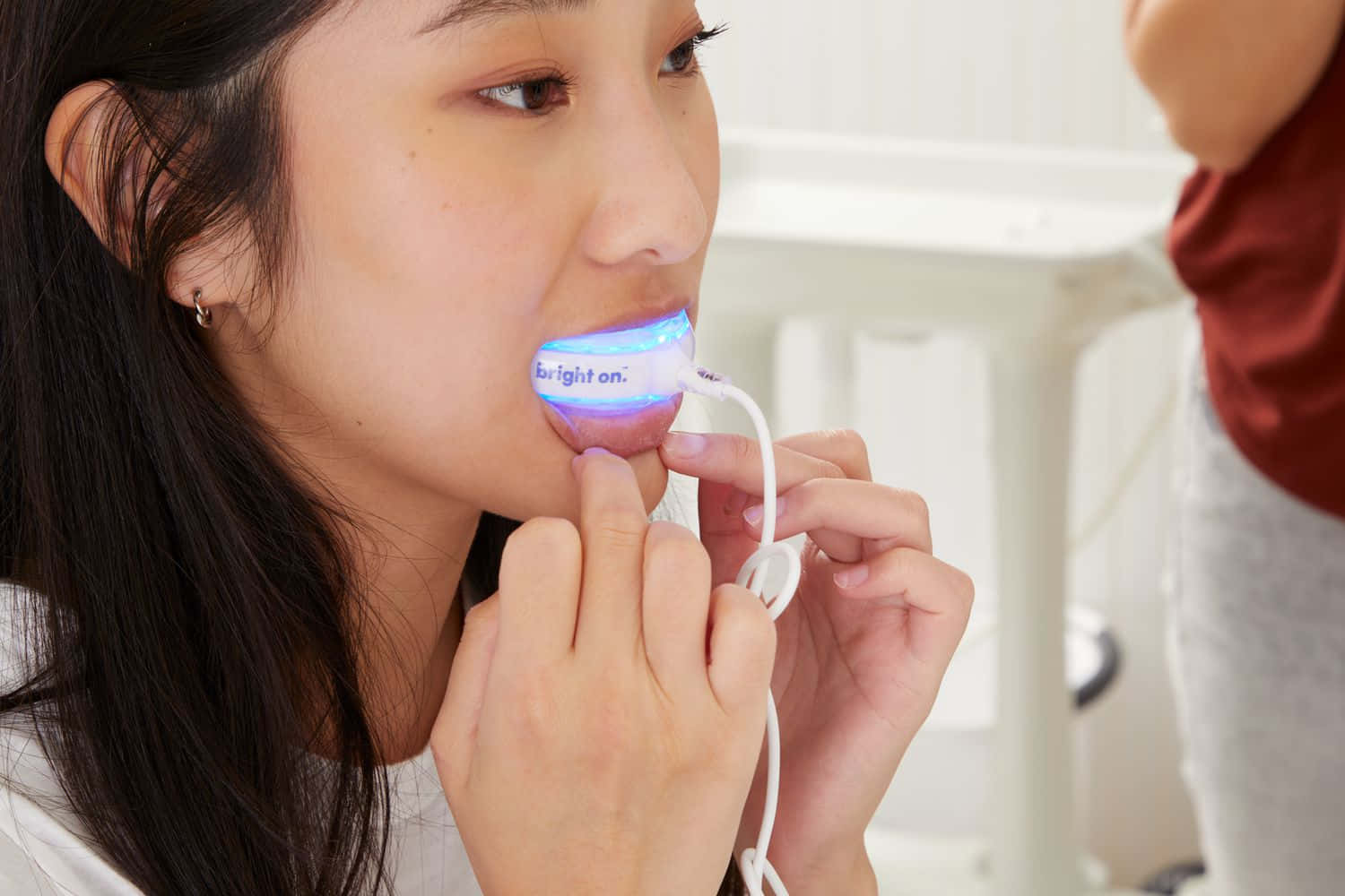 glowing blue oral appliance, bright clinical setting, young woman, HD Desktop Wallpaper