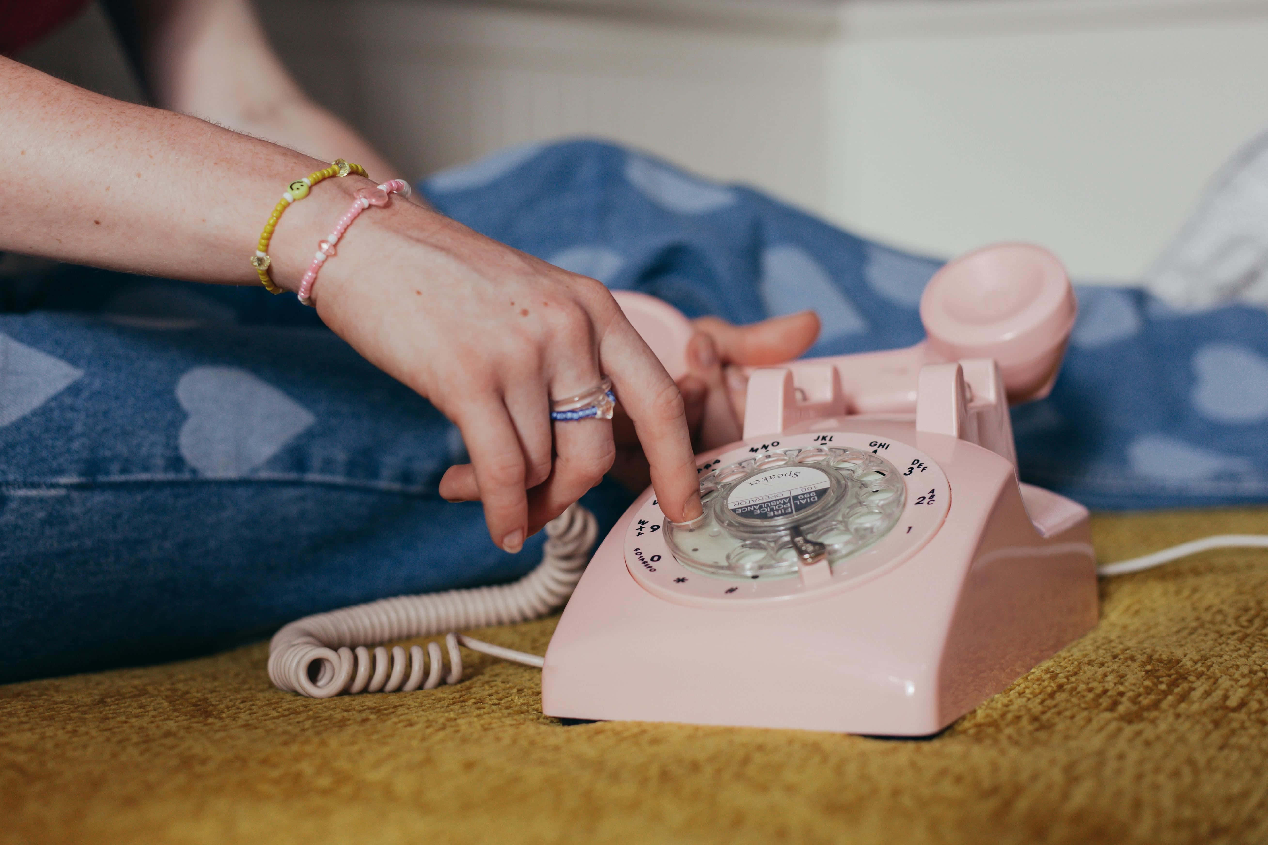 vintage pink rotary phone, mustard yellow carpet, colorful bracelets, 5K Desktop Wallpaper