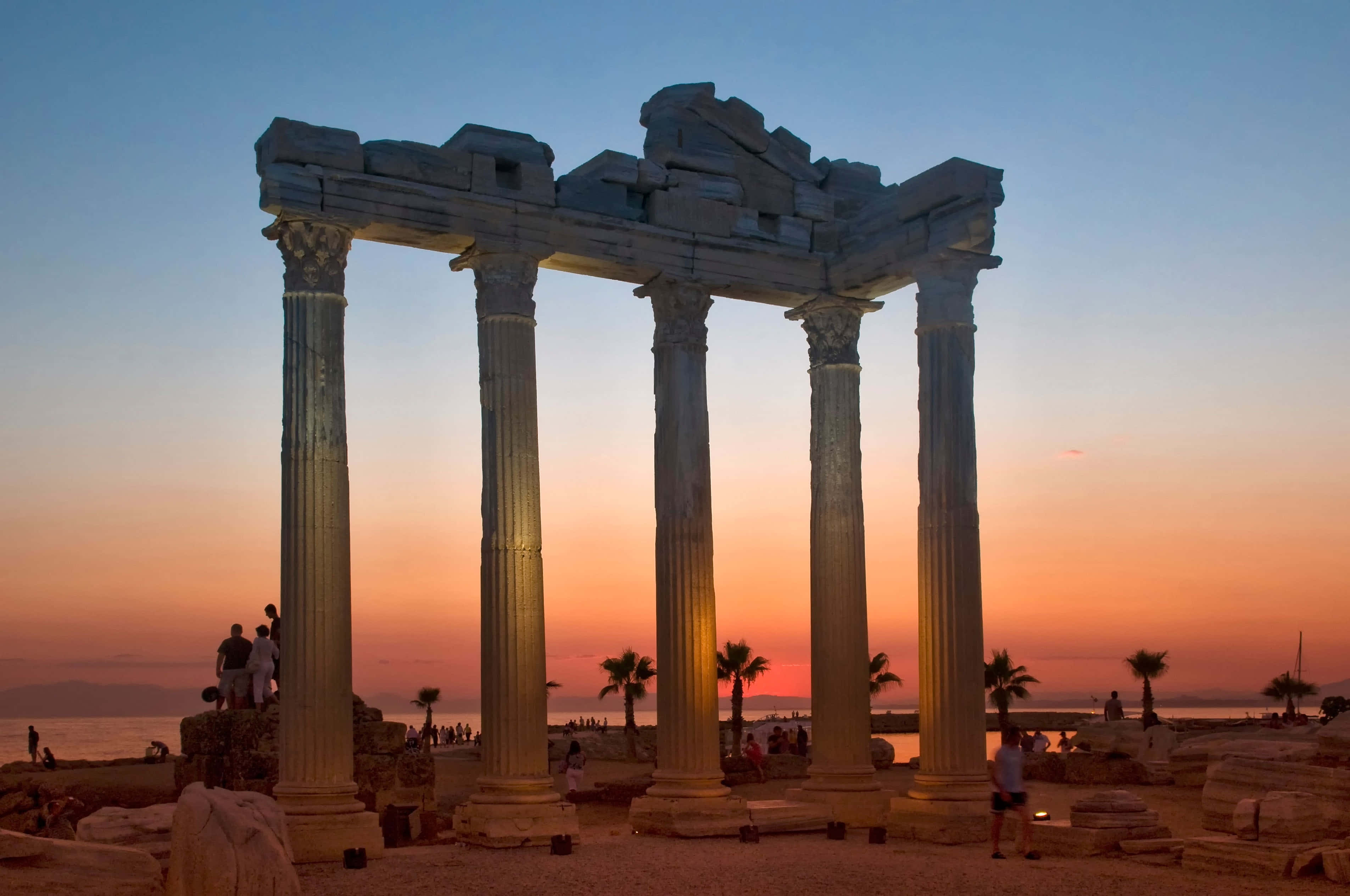 Temple Of Apollo, ancient stone columns, fiery sunset sky, 2K Desktop Wallpaper