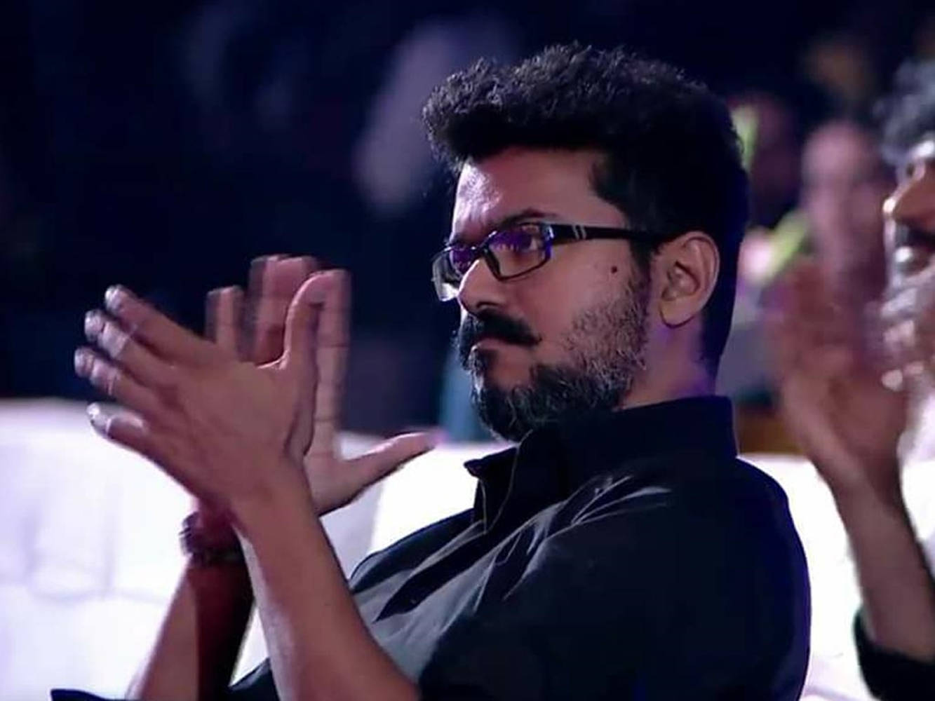 Thalapathy Vijay, clapping, dimly lit audience setting, HD Desktop Wallpaper