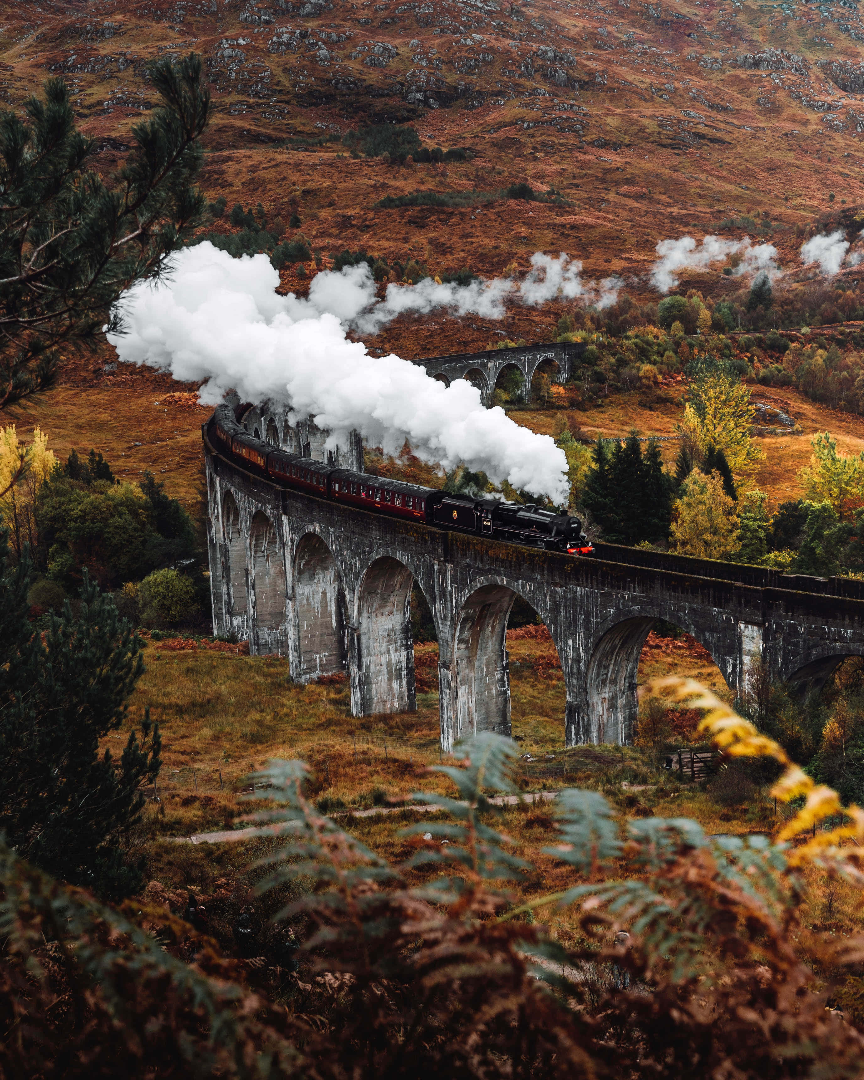 Hogwarts Express, stone viaduct, autumnal hillsides, 2K Phone Wallpaper