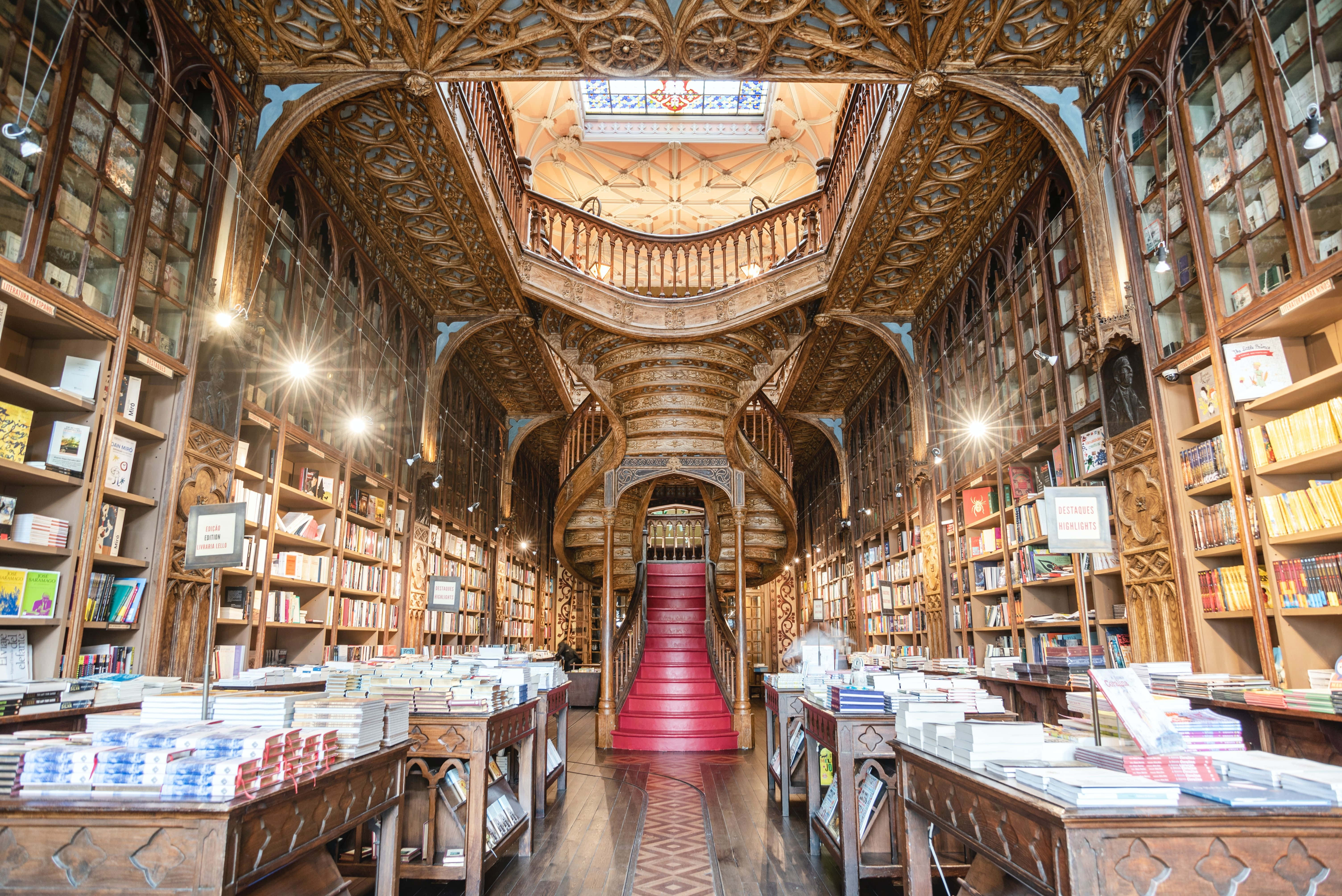 The Hogwarts Library, wooden bookshelves, red-carpeted staircase, 5K Desktop Wallpaper