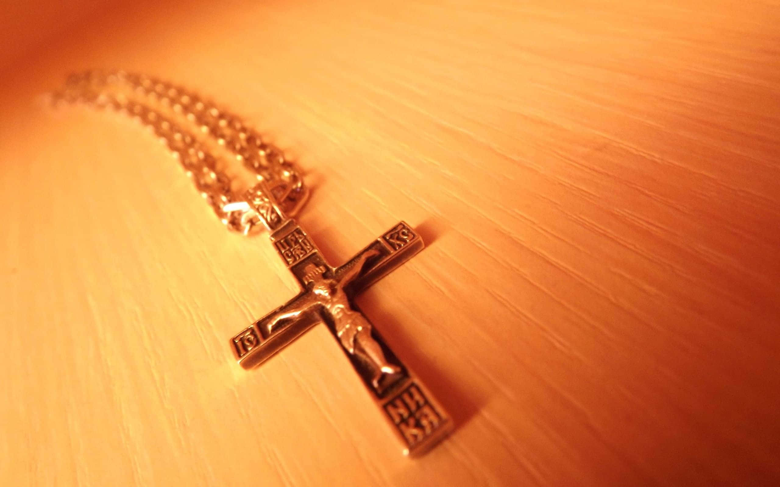 Theology, golden crucifix necklace, warm wooden surface, 2K Desktop Wallpaper