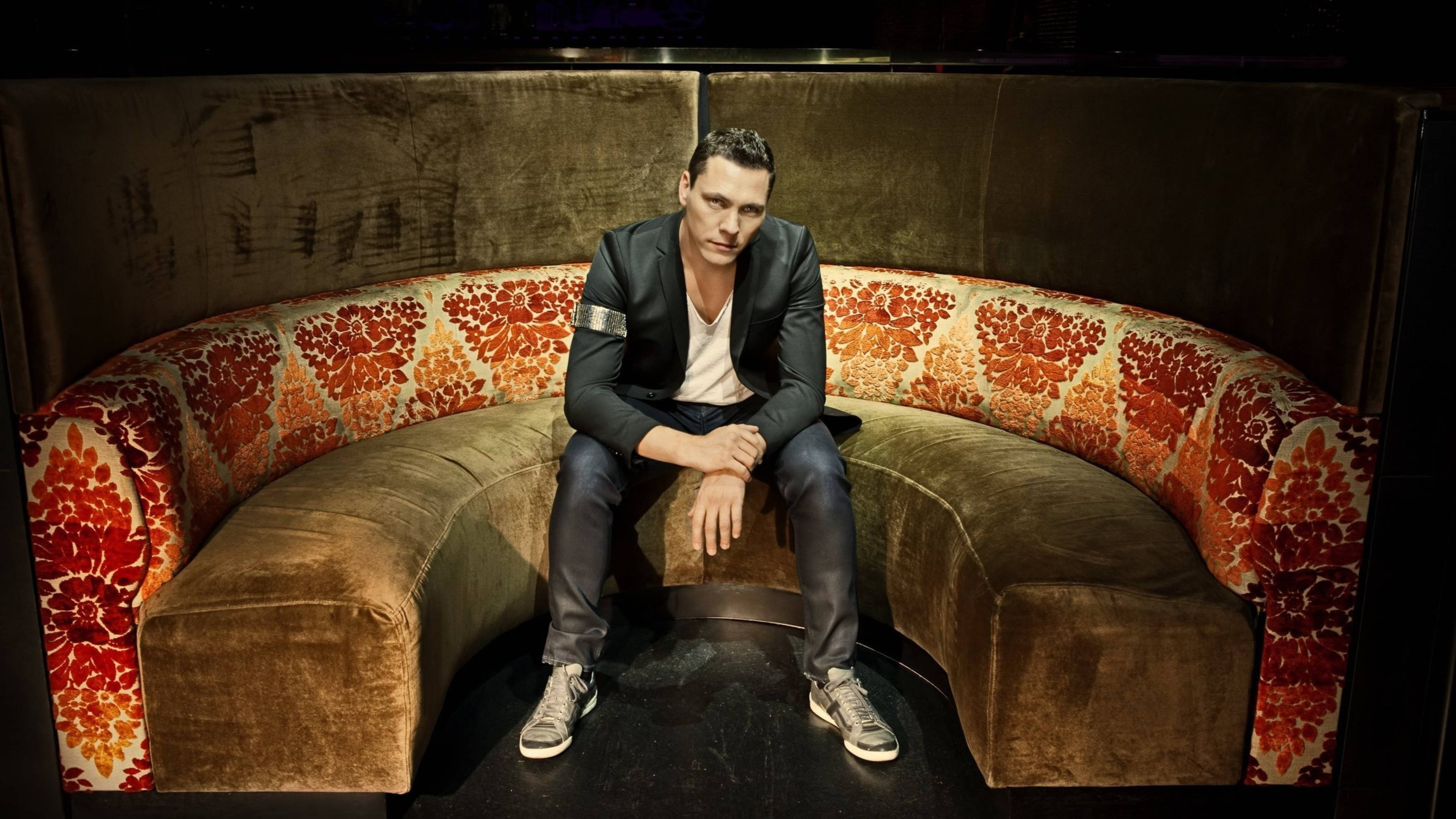Tiesto, all-black suit, curved velvet sofa, 4K Desktop Wallpaper