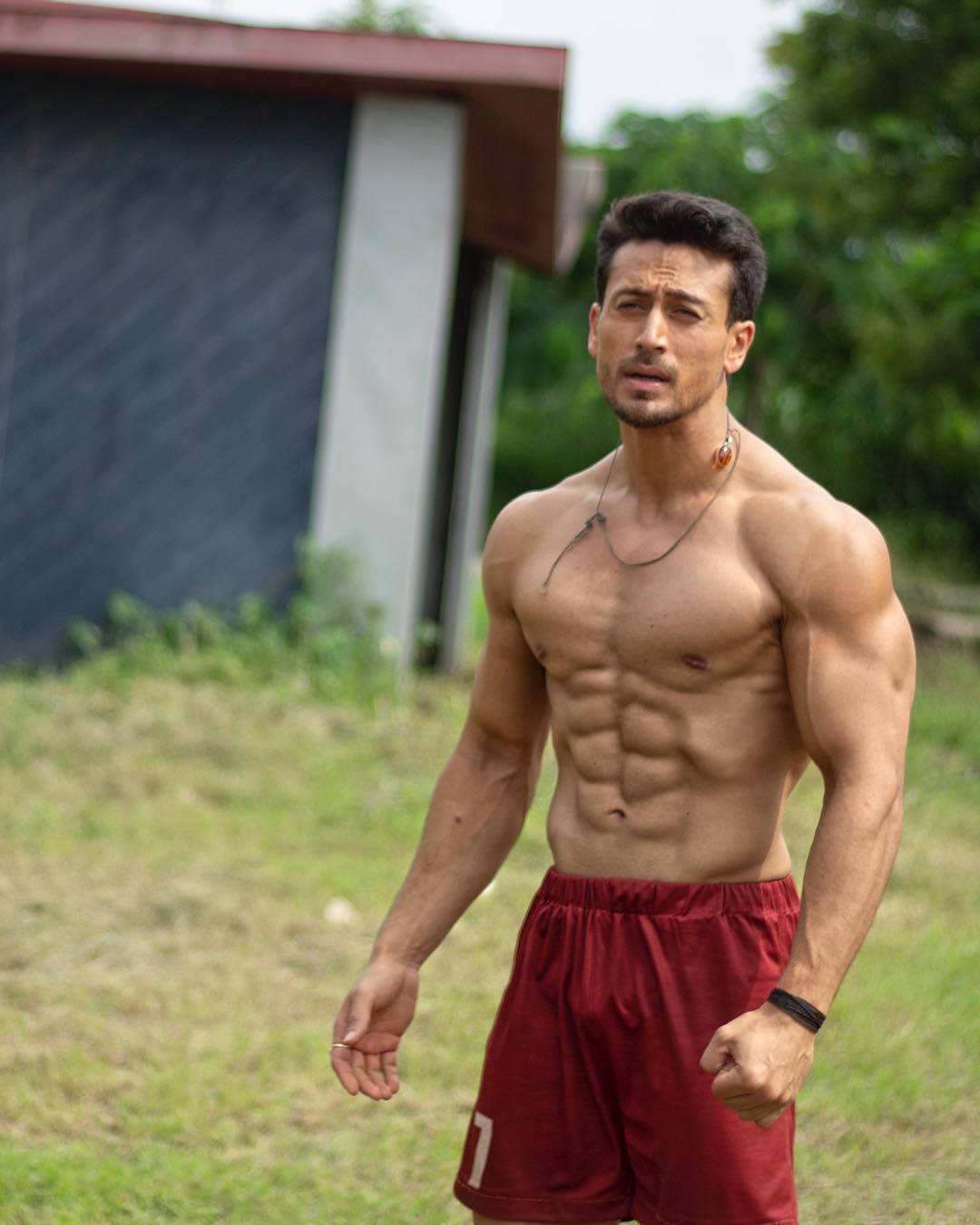 Tiger Shroff, red shorts, blurred building, HD Phone Wallpaper