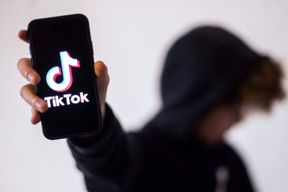 TikTok logo, black hoodie, smartphone, SD Desktop Wallpaper