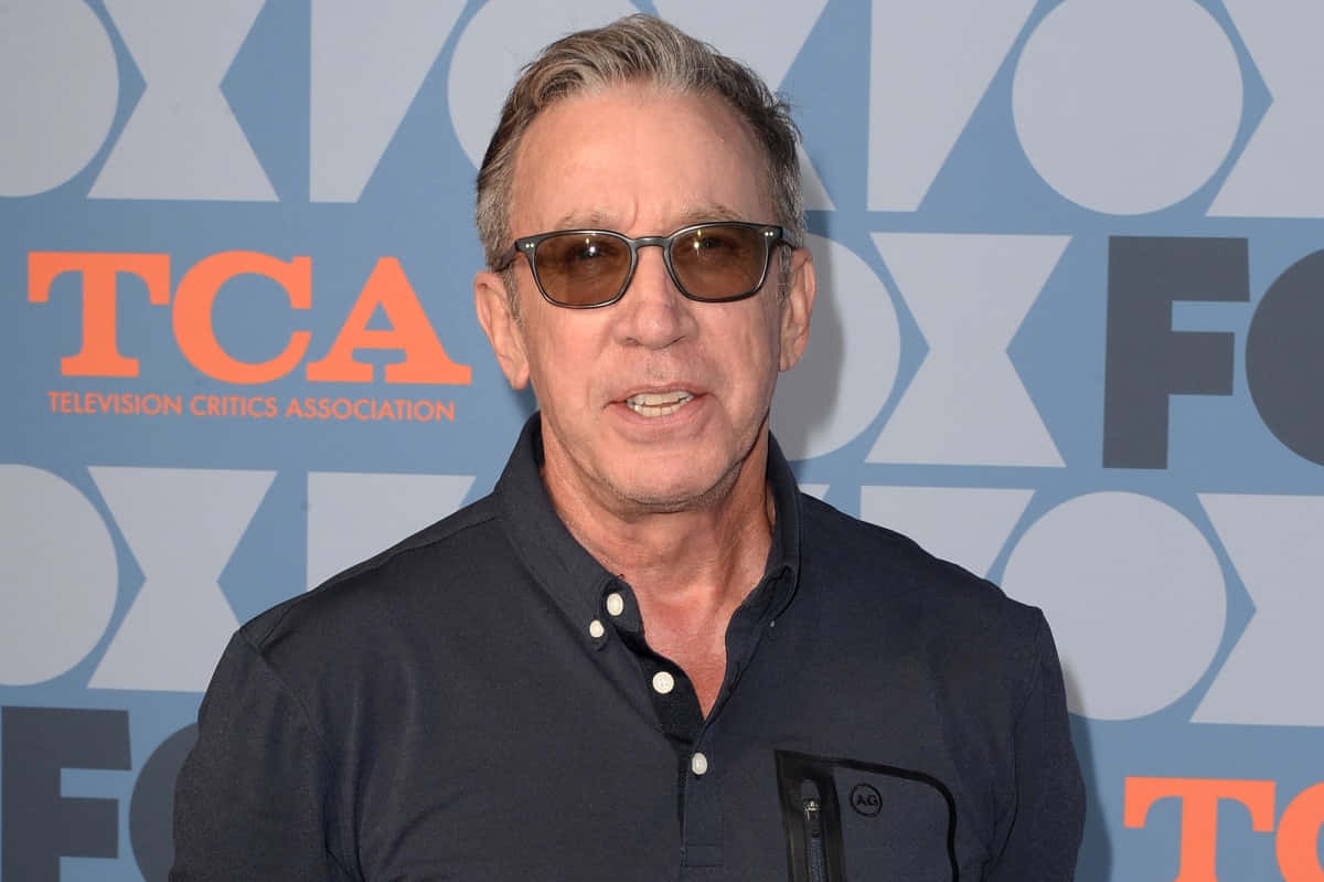 Tim Allen, blue TCA backdrop, orange lettering, SD Desktop Wallpaper
