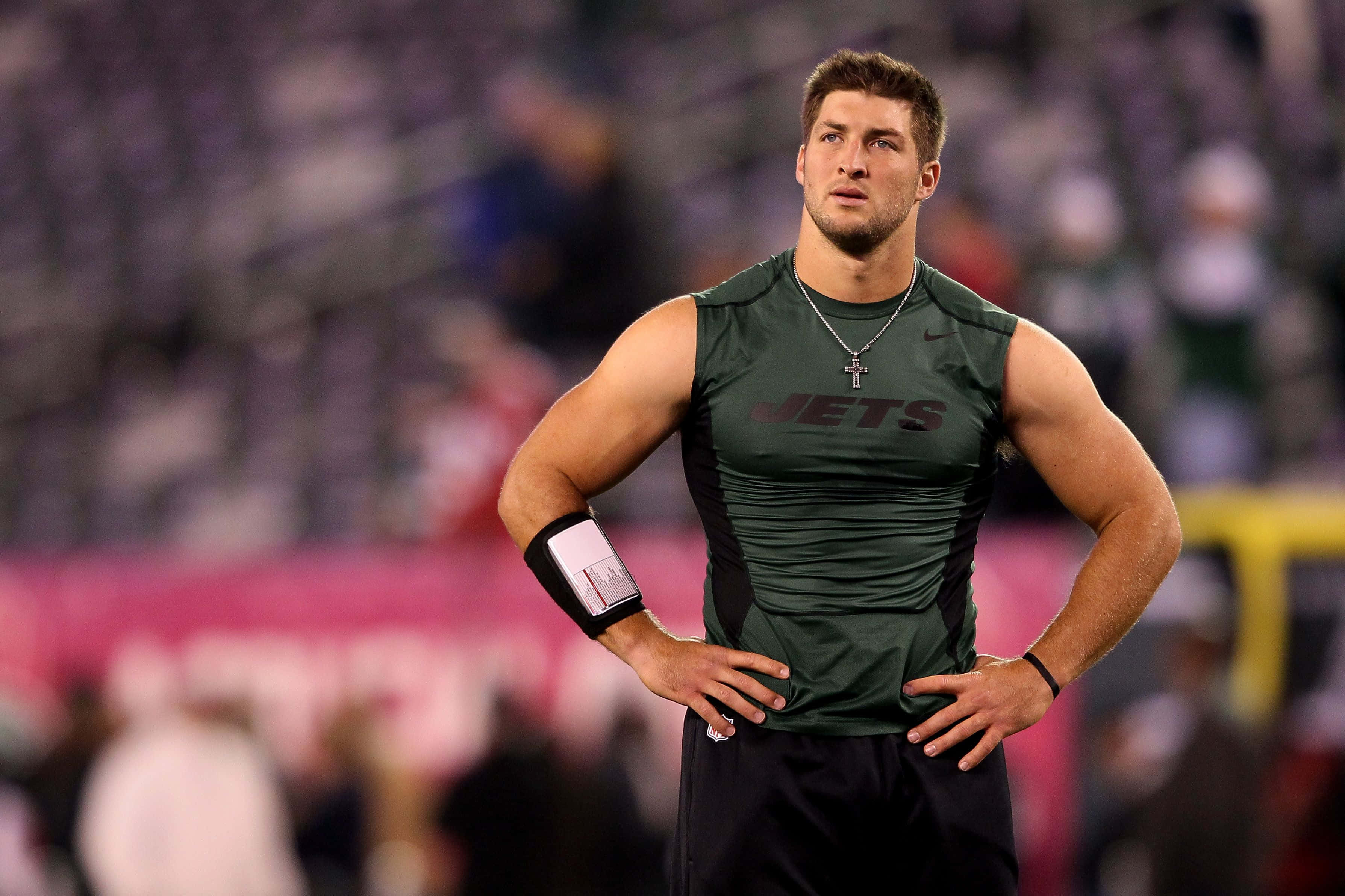 Tim Tebow, green sleeveless jersey, lit field, 2K Desktop Wallpaper