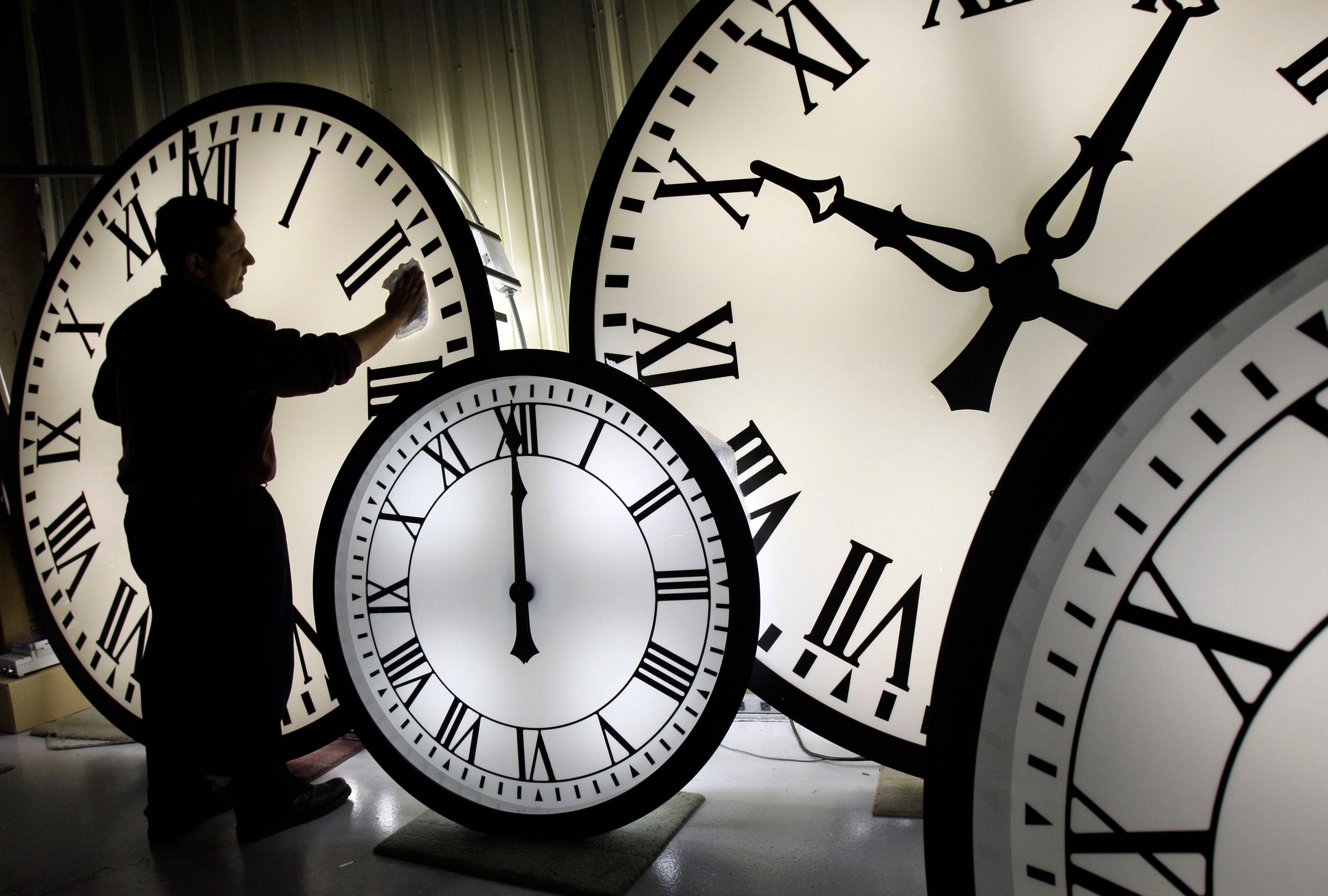 giant illuminated clock face, oversized Roman numeral clocks, dim workshop, 2K Desktop Wallpaper