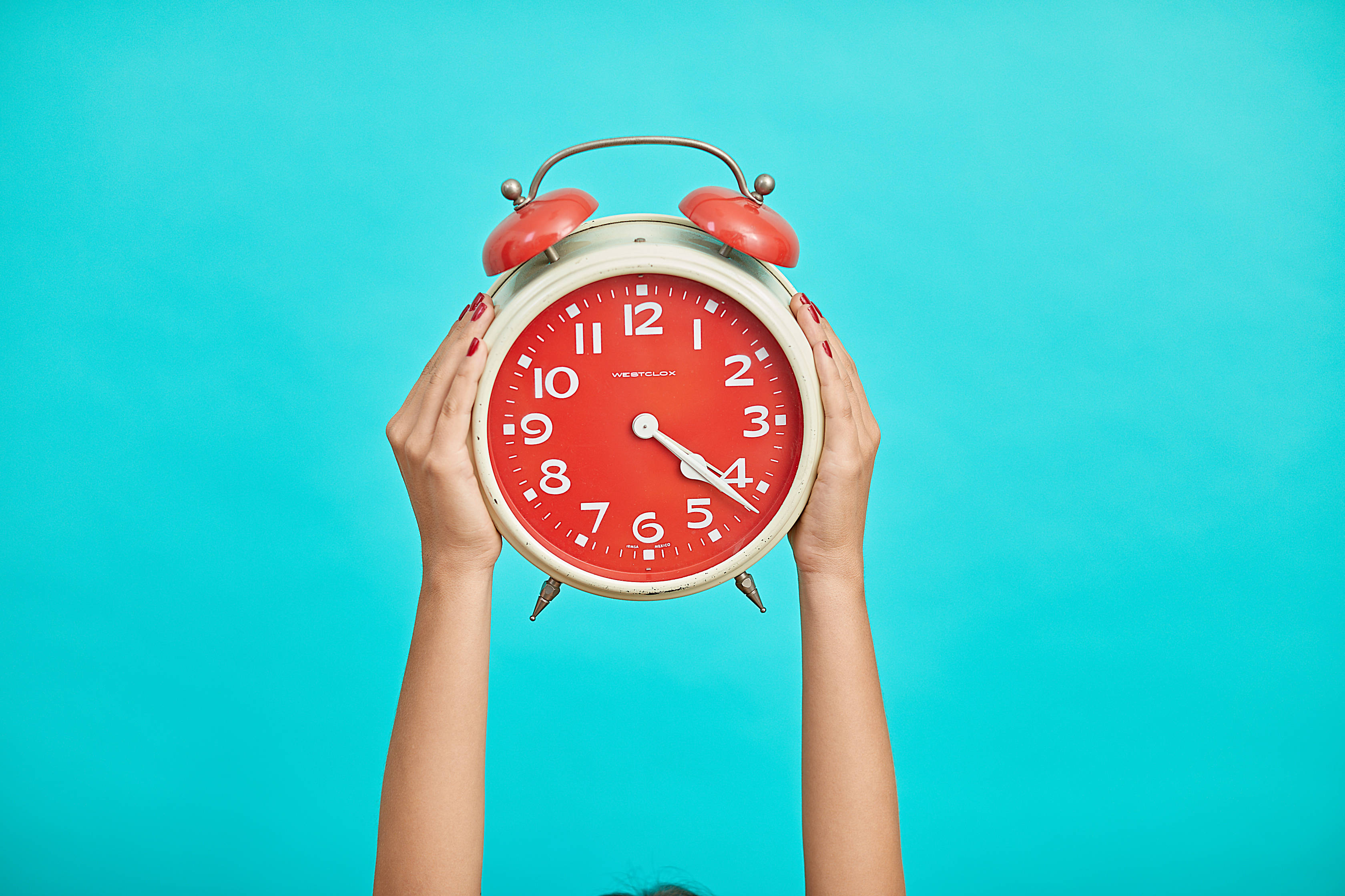 vintage red alarm clock, bright turquoise background, blue green scrim, 2K Desktop Wallpaper