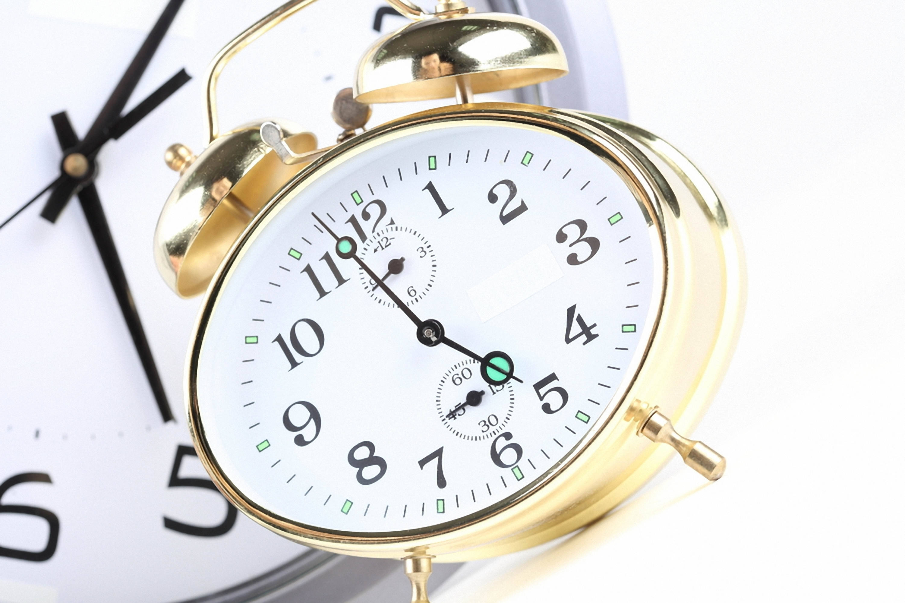 gold alarm clock, green accents, blurred wall clock, 2K Desktop Wallpaper