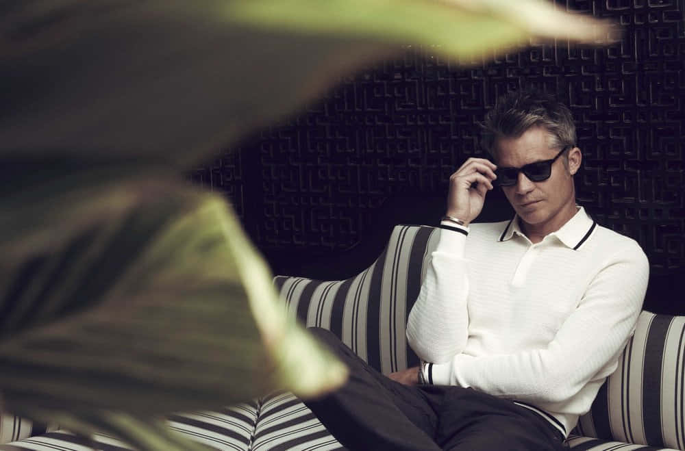 Timothy Olyphant, striped couch, blurred green foliage, SD Desktop Wallpaper
