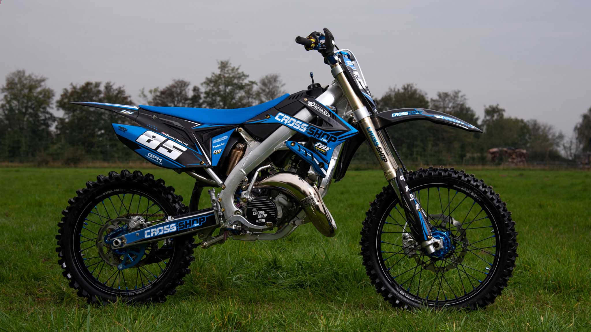 TM Racing, blue and black Crosshatch dirt bike, grassy field, Full HD Desktop Wallpaper