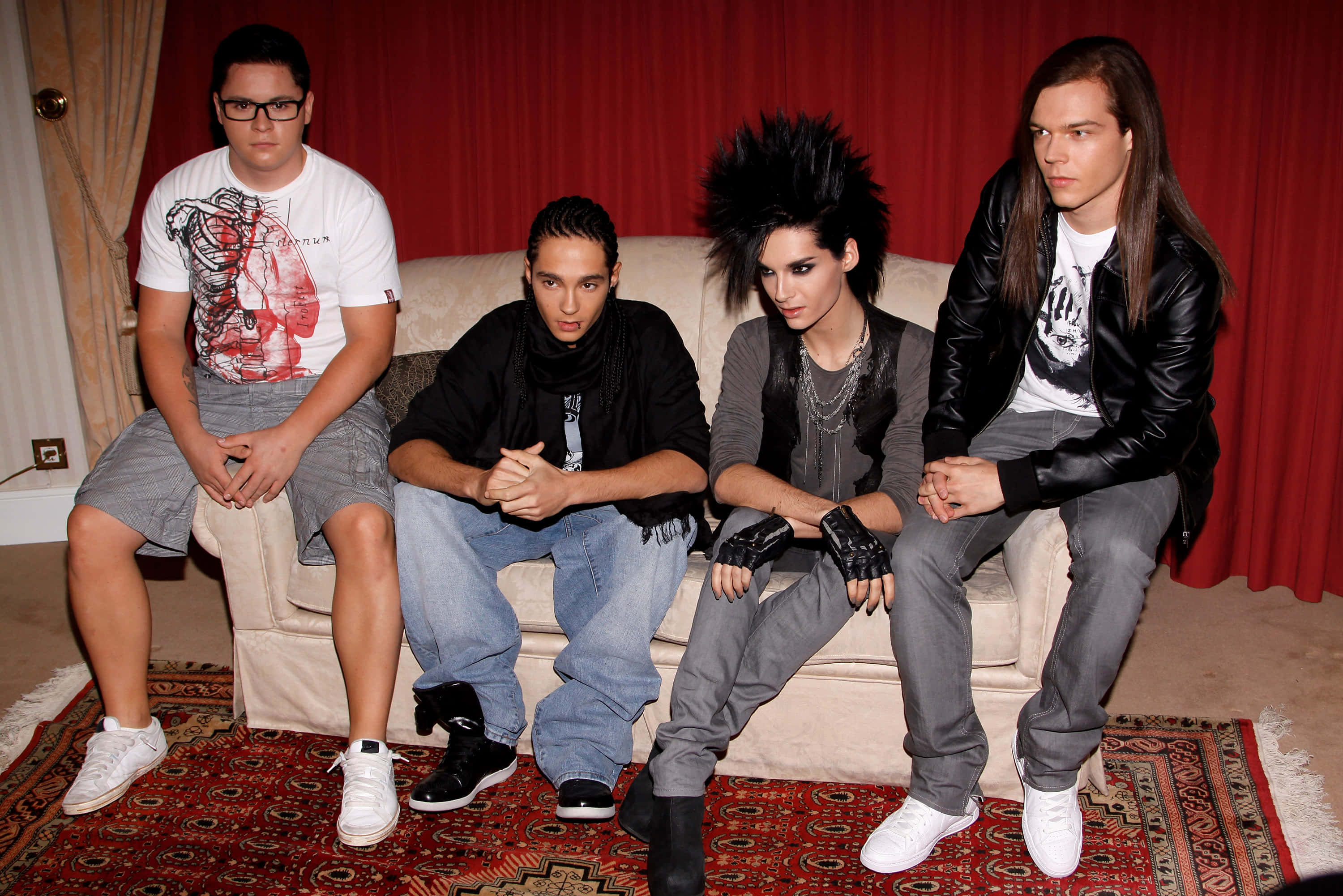 Tokio Hotel, beige couch, red curtain backdrop, 2K Desktop Wallpaper