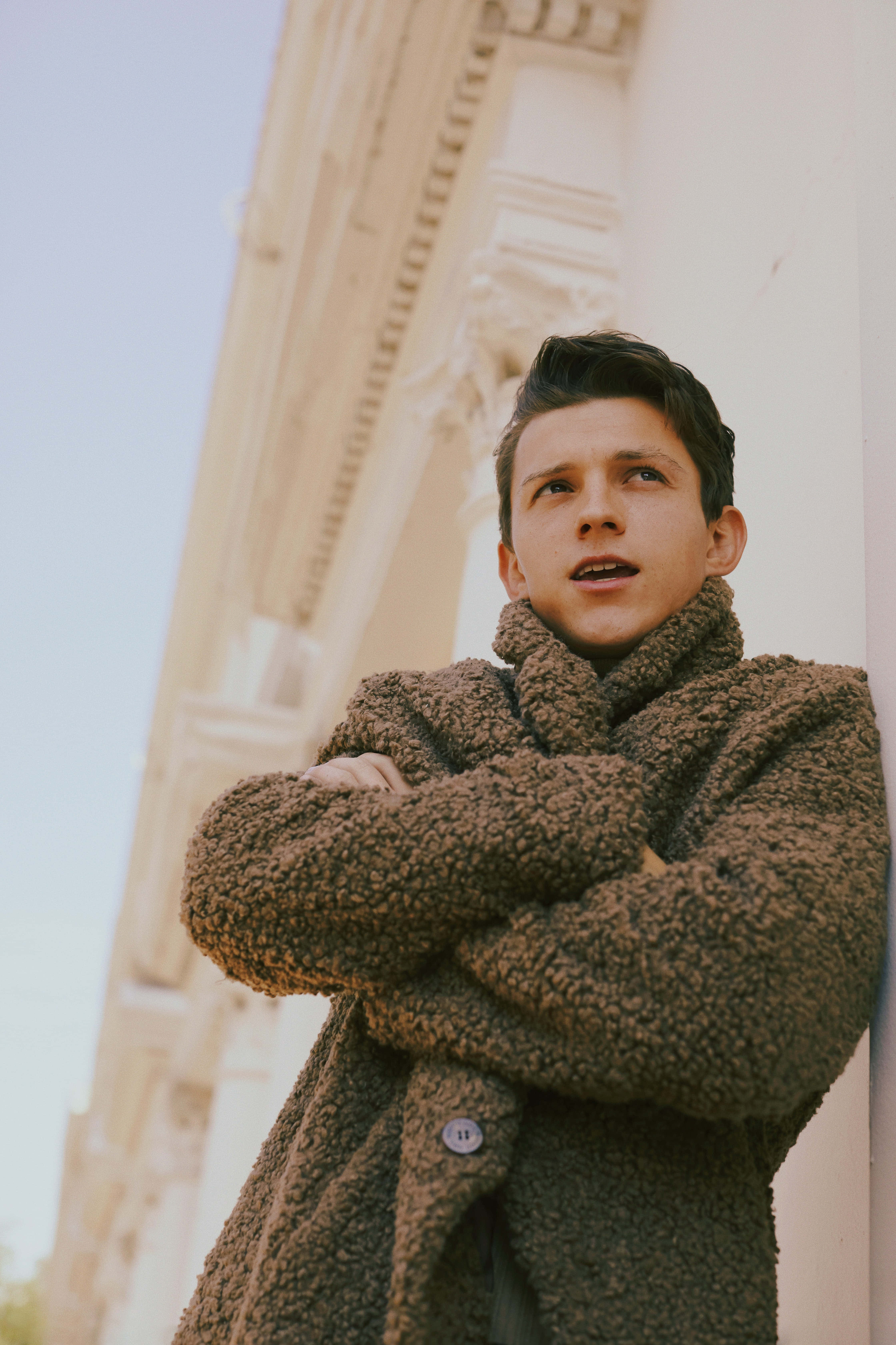 Tom Holland, textured brown coat, classical building facade, 5K Phone Wallpaper