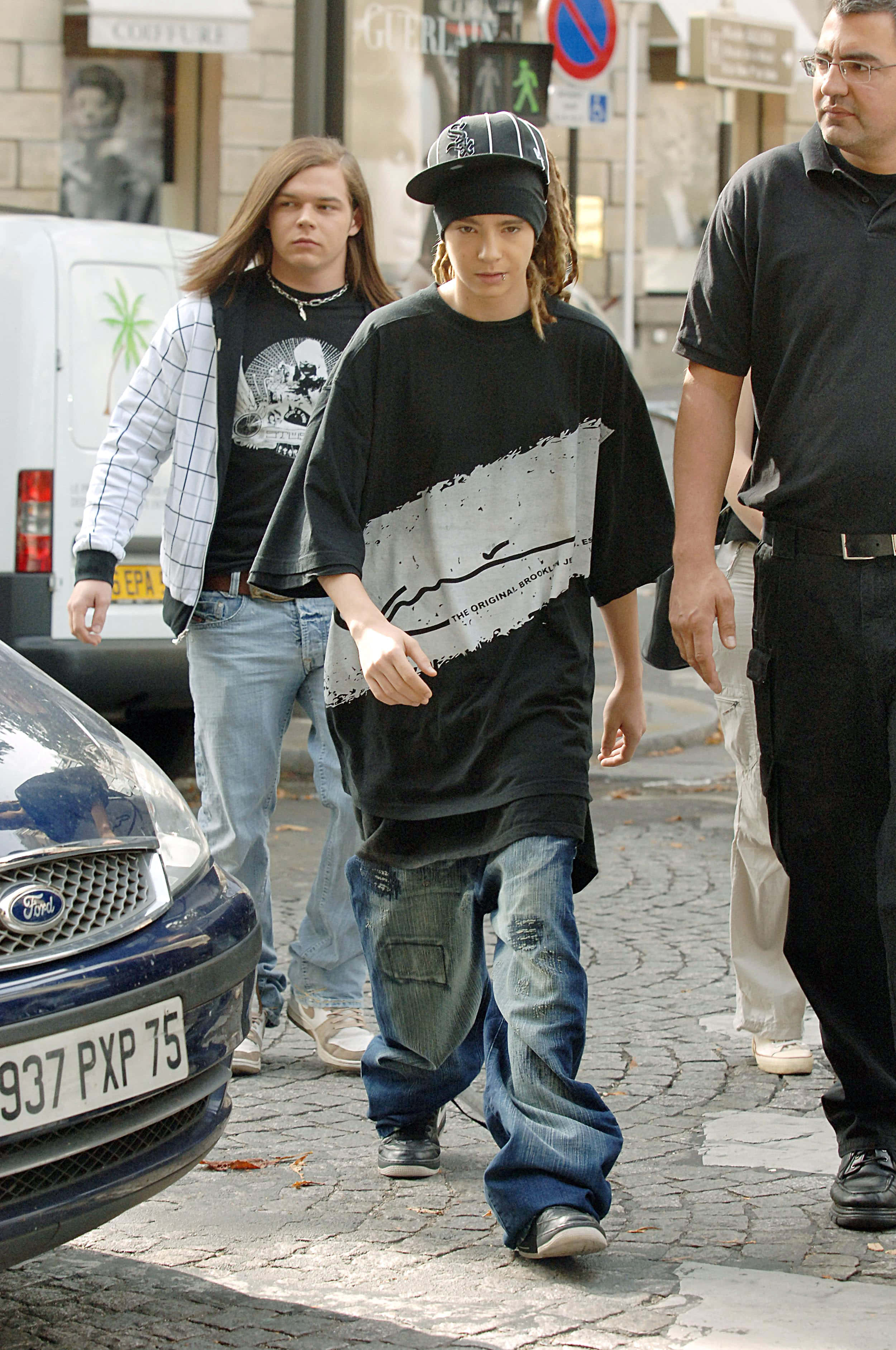 Tom Kaulitz, streetwear, sunlit cobblestone street, 2K Phone Wallpaper