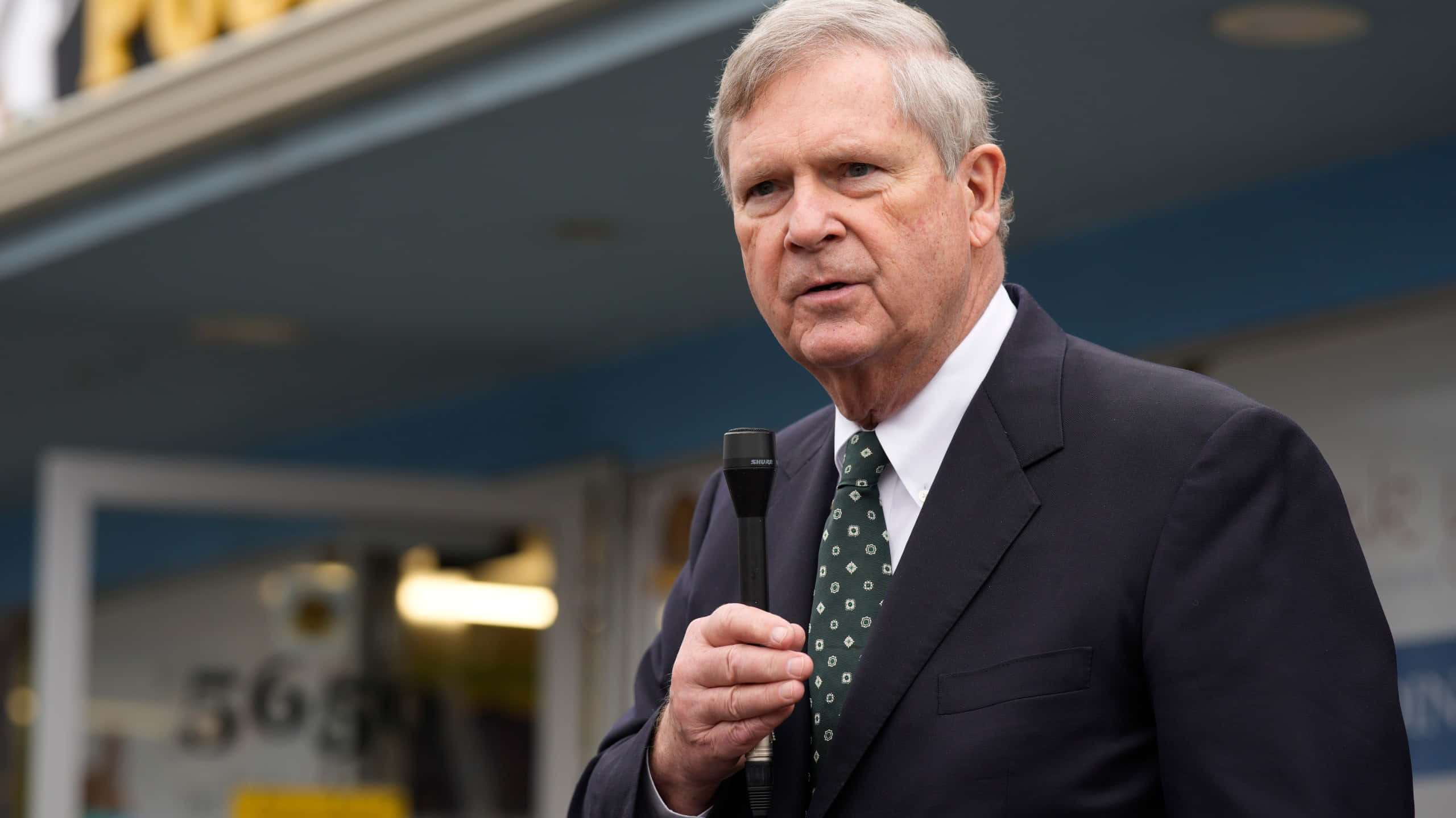 Tom Vilsack, microphone, dark suit, 2K Desktop Wallpaper