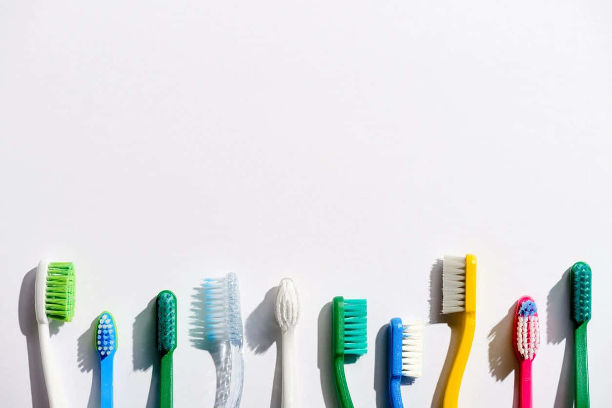 colorful toothbrushes, varied bristle designs, bright white background, SD Desktop Wallpaper
