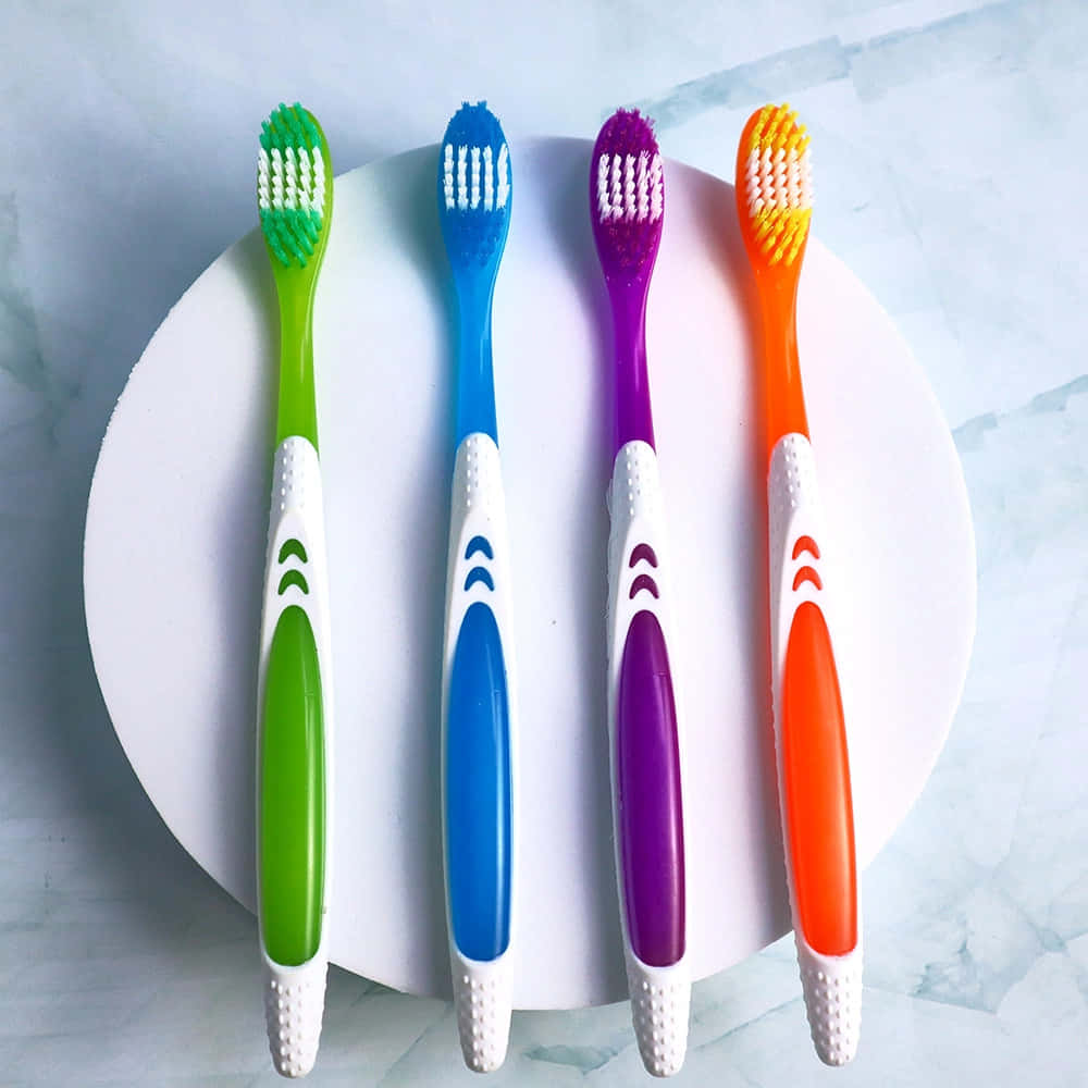 colorful toothbrushes array, green blue purple orange handles, white circular plate, SD Desktop Wallpaper