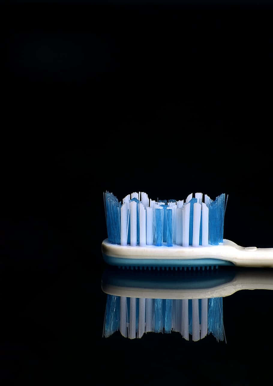 blue and white toothbrush, worn bristles, black reflective surface, HD Phone Wallpaper