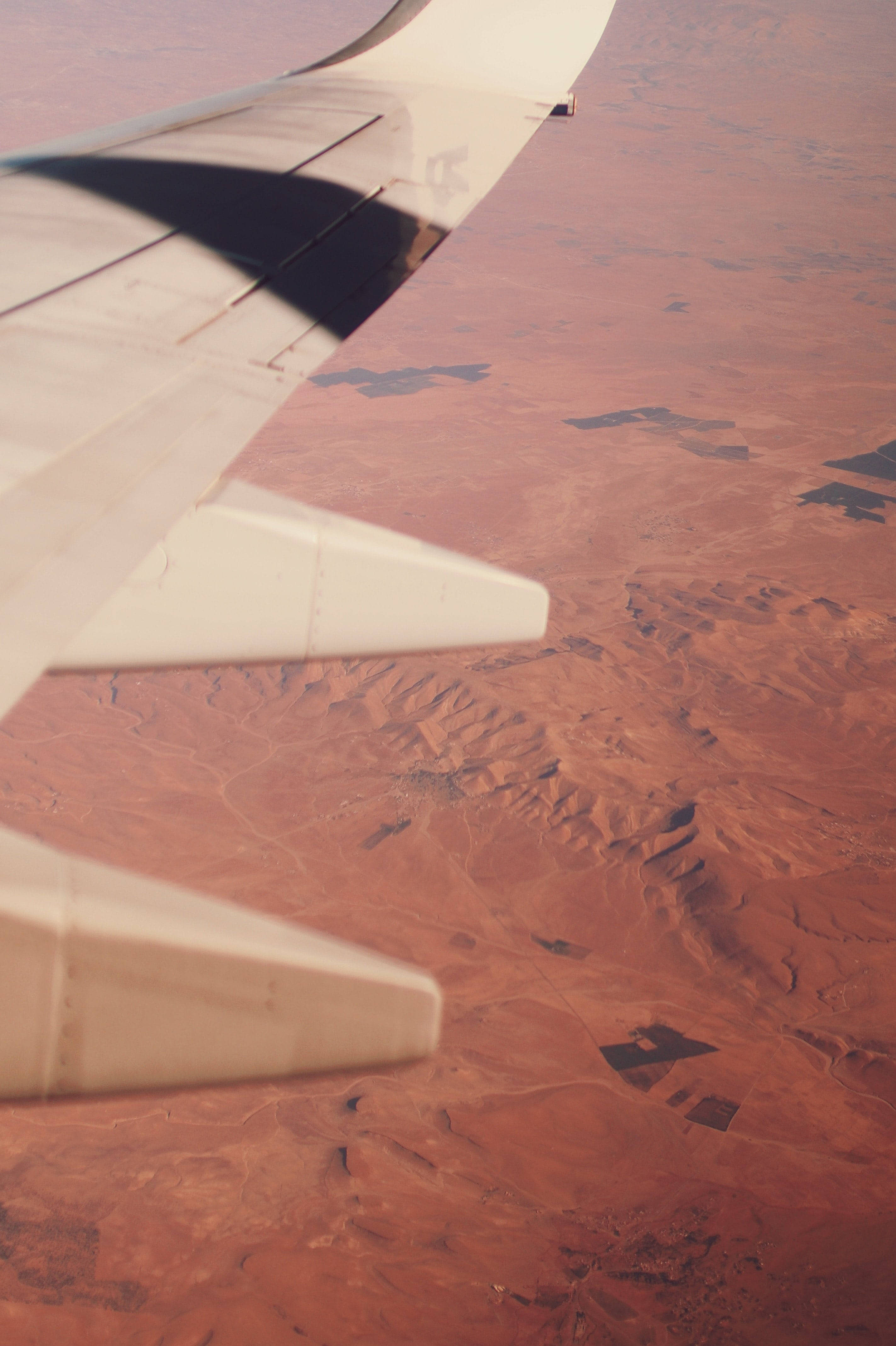Aircraft wing, vast red desert terrain, high altitude, 4K Phone Wallpaper