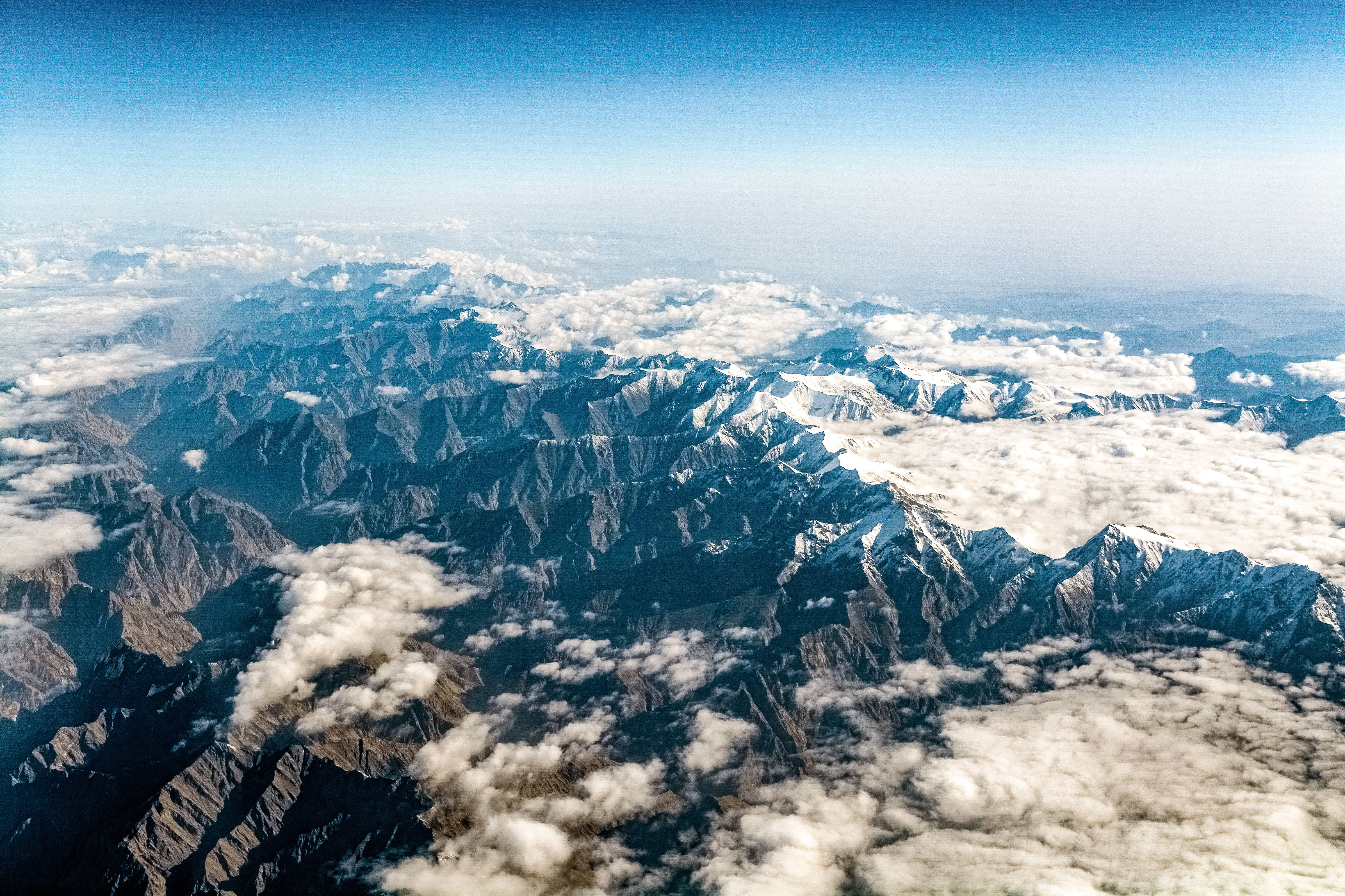 cloudy mountain topography, jagged snowcapped mountains, fluffy white clouds, 5K Desktop Wallpaper