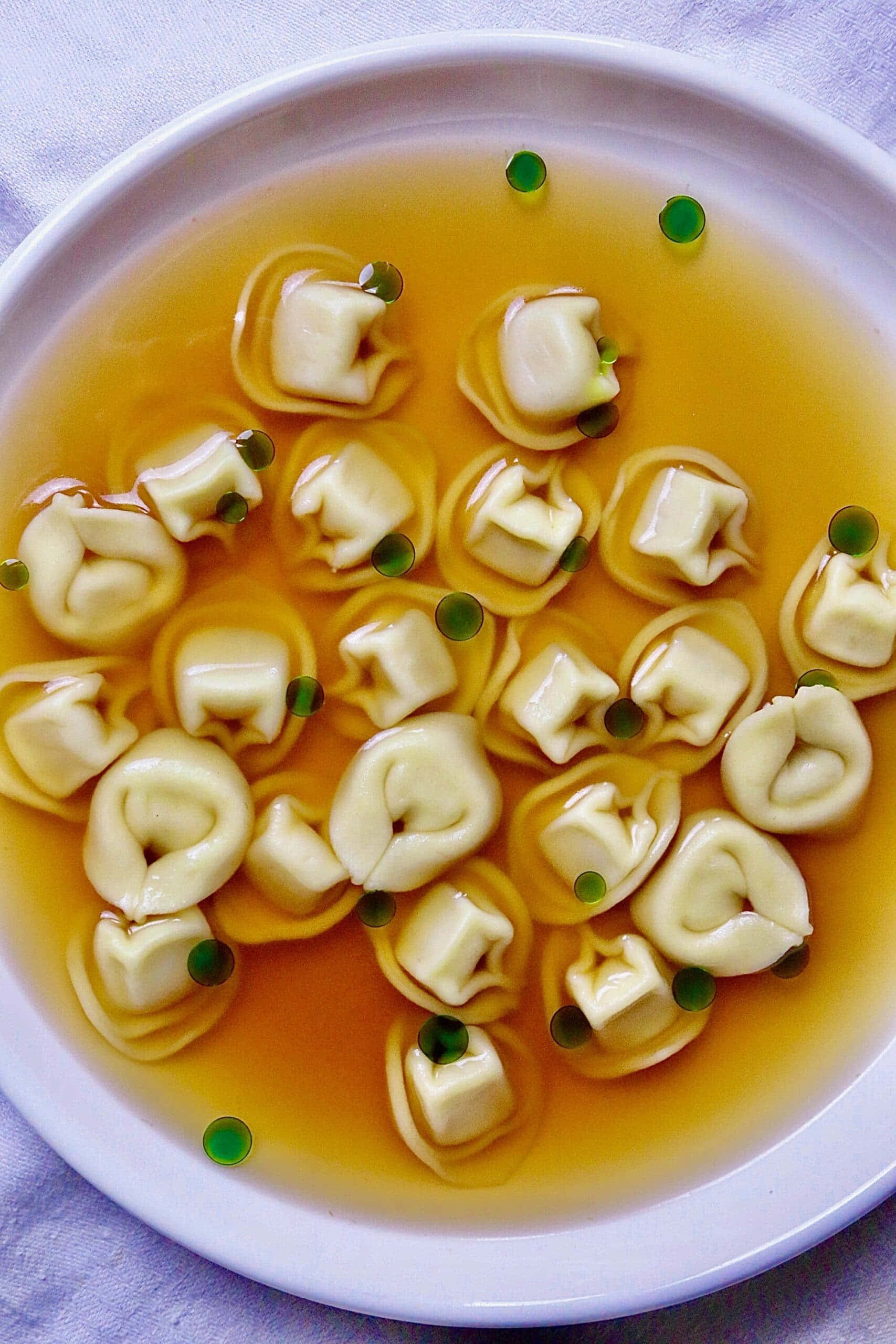 Tortellini In Brodo, purple plate, golden broth, 2K Phone Wallpaper