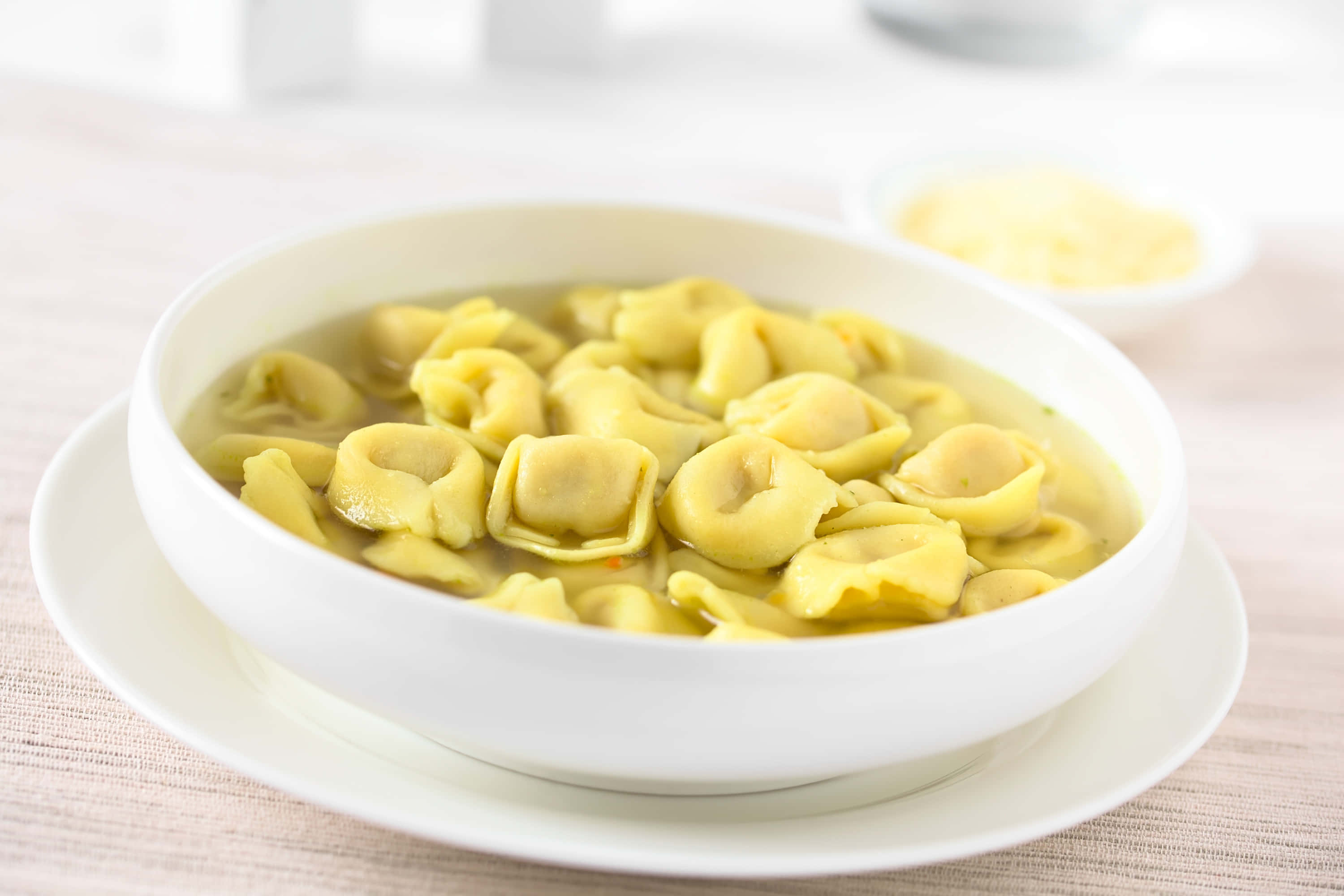 bowl full of tortellini in brodo, golden tortellini, clear broth, 2K Desktop Wallpaper