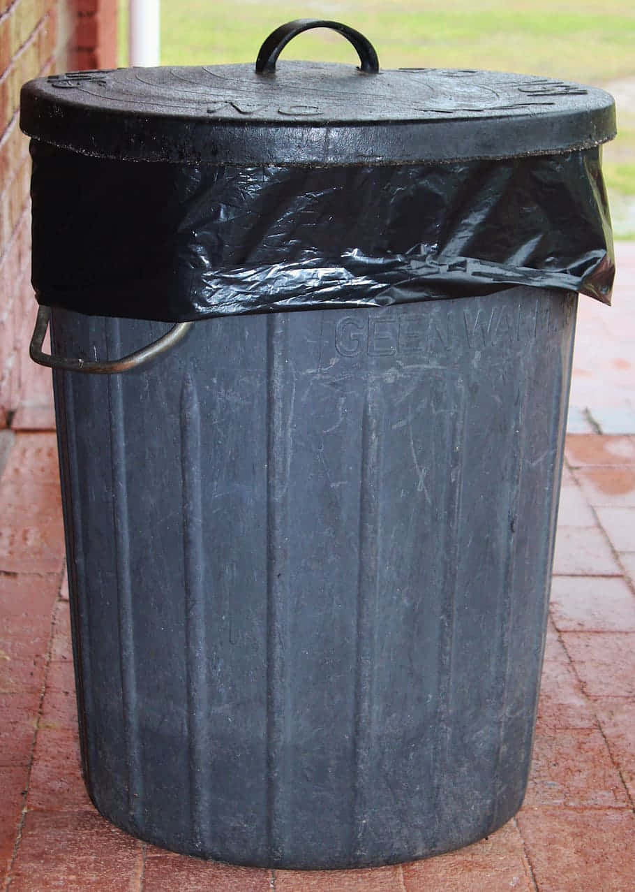 black plastic barrel trash can, plastic liner, red brick patio, SD Phone Wallpaper