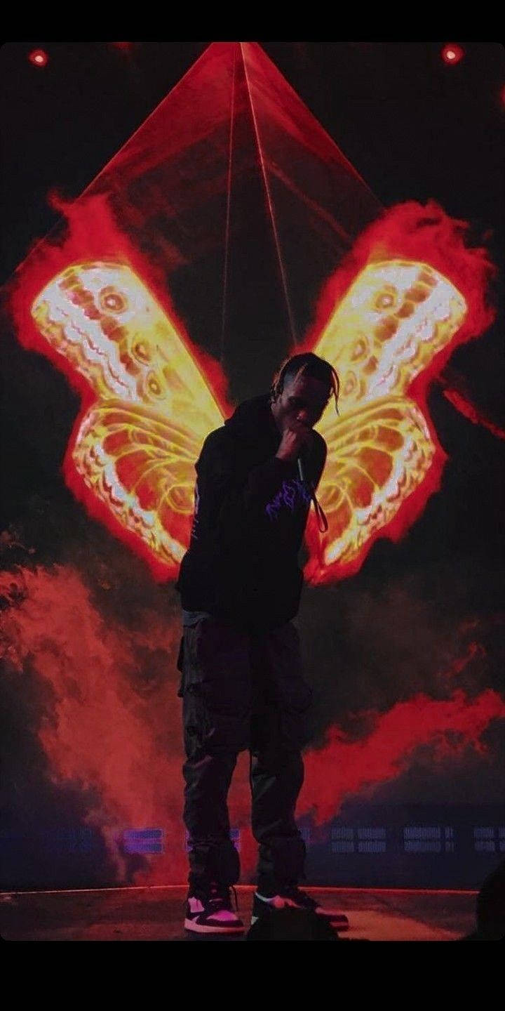 Travis Scott Aesthetic, glowing red and yellow butterfly wings, smoky concert setting, HD Phone Wallpaper