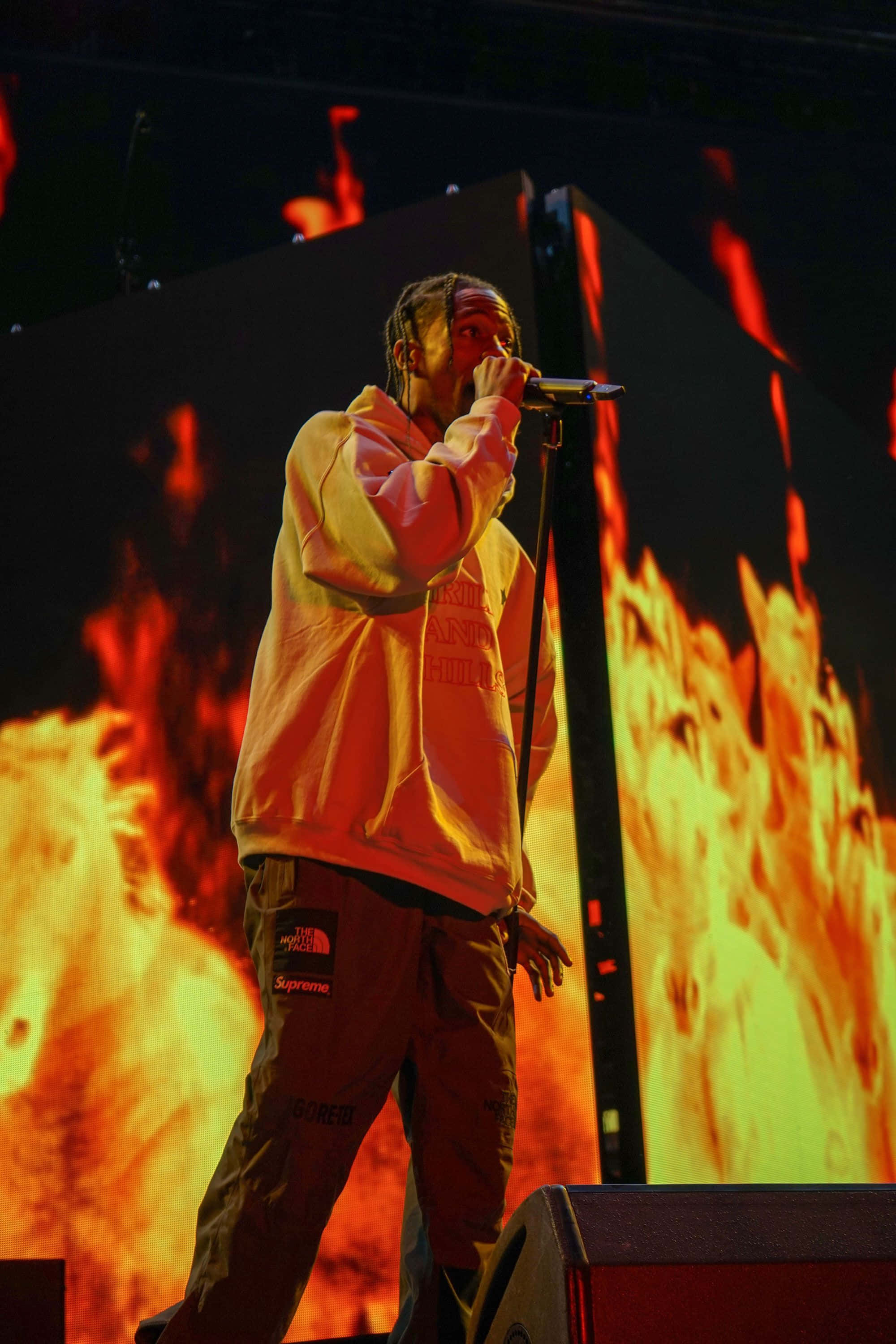 Travis Scott Concert, yellow hoodie, fiery orange and red digital backdrop, 2K Phone Wallpaper