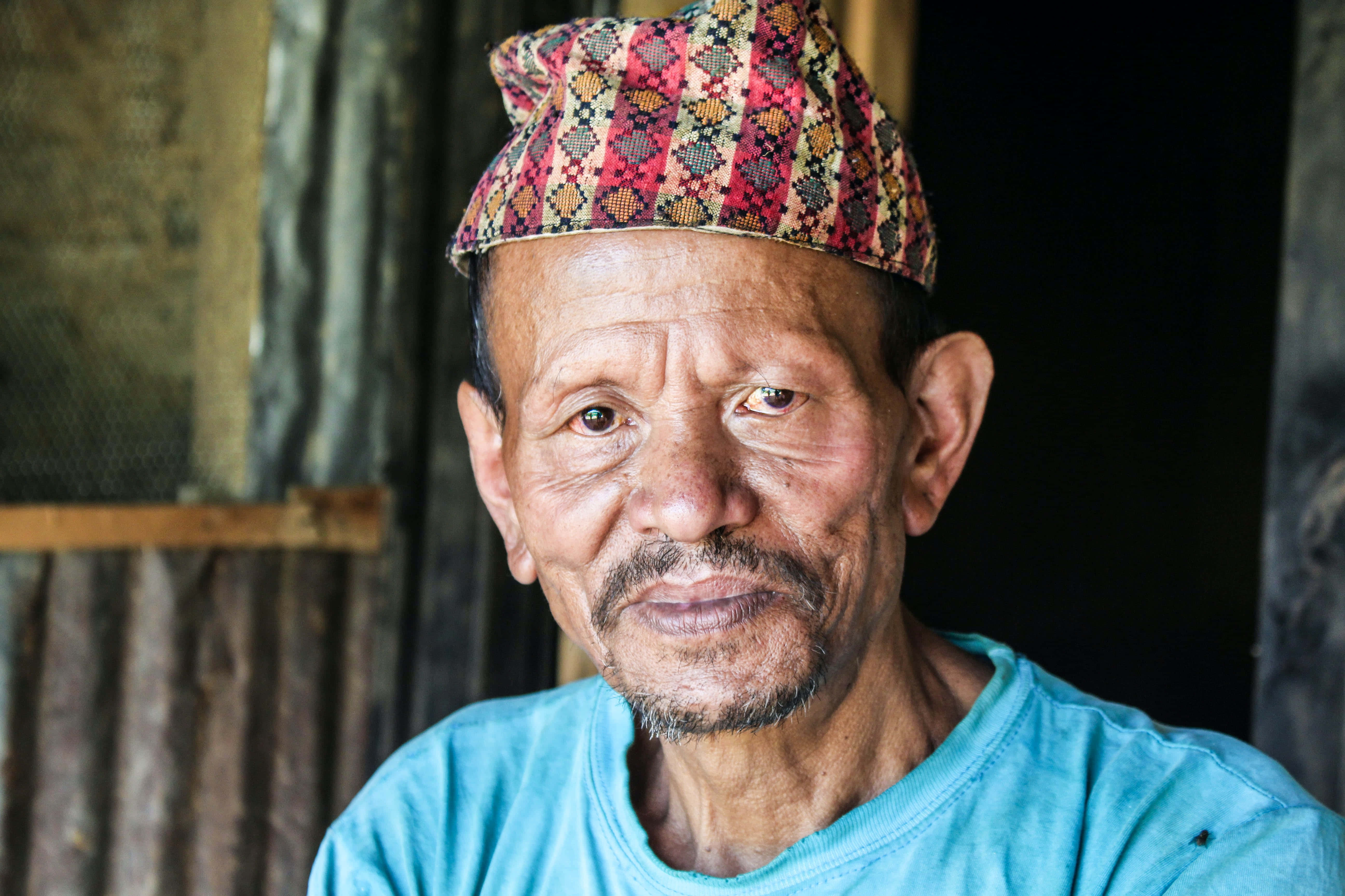 mature tribal man, colorful patterned cap, blue shirt, 5K Desktop Wallpaper
