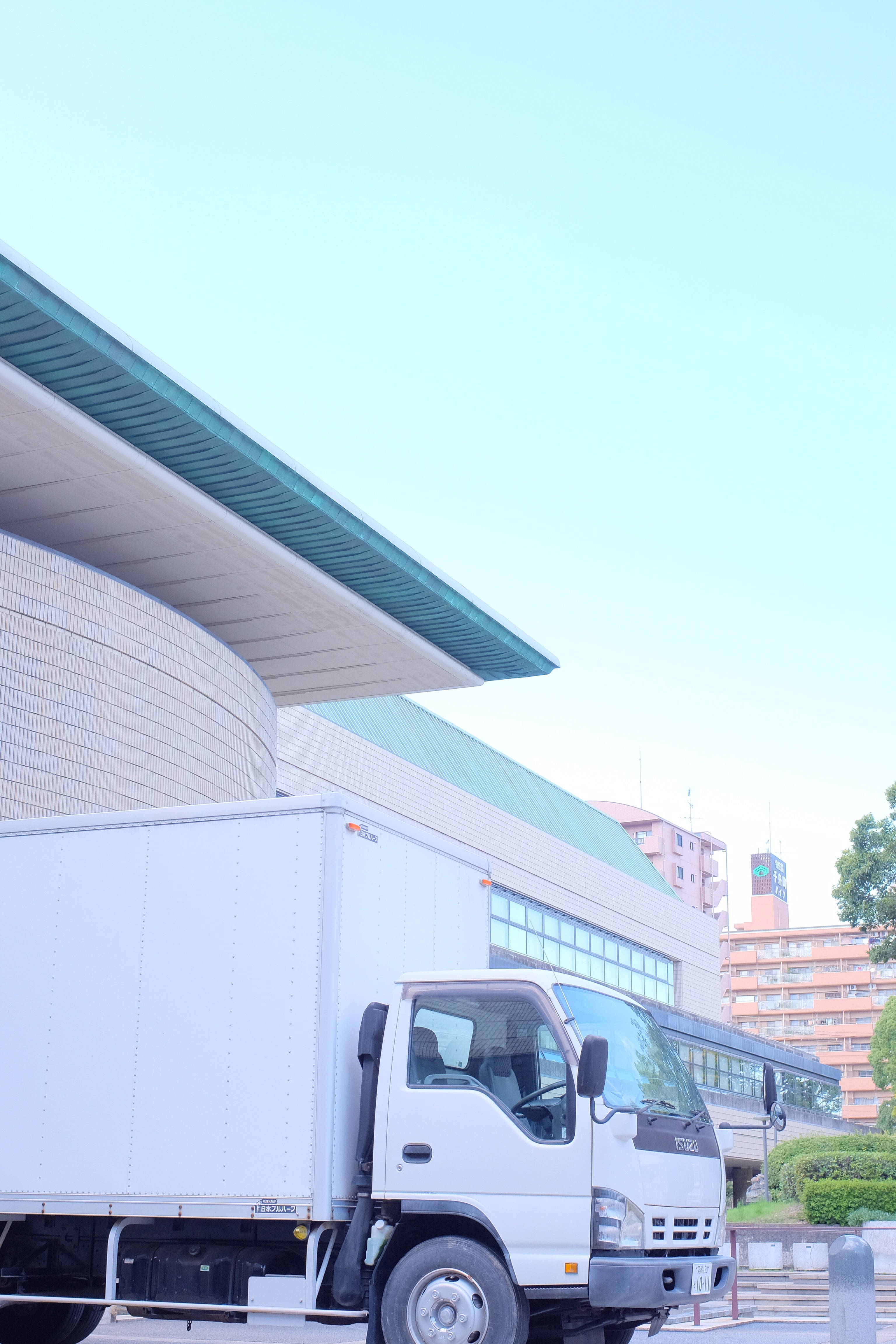 white delivery truck, modern curved building, teal accents, 4K Phone Wallpaper