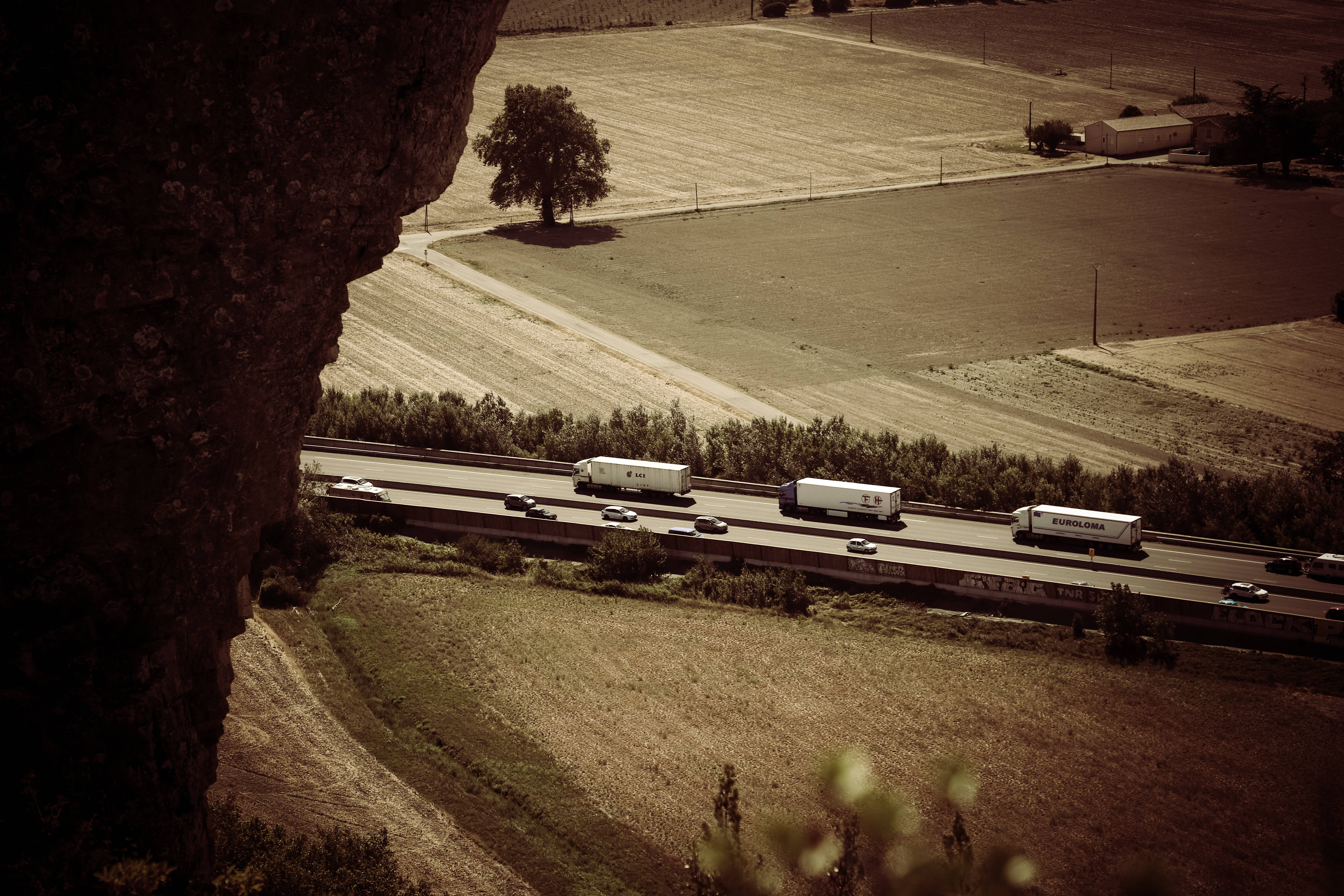 sepia-toned highway, sunlit rural valley, trucks, 5K Desktop Wallpaper