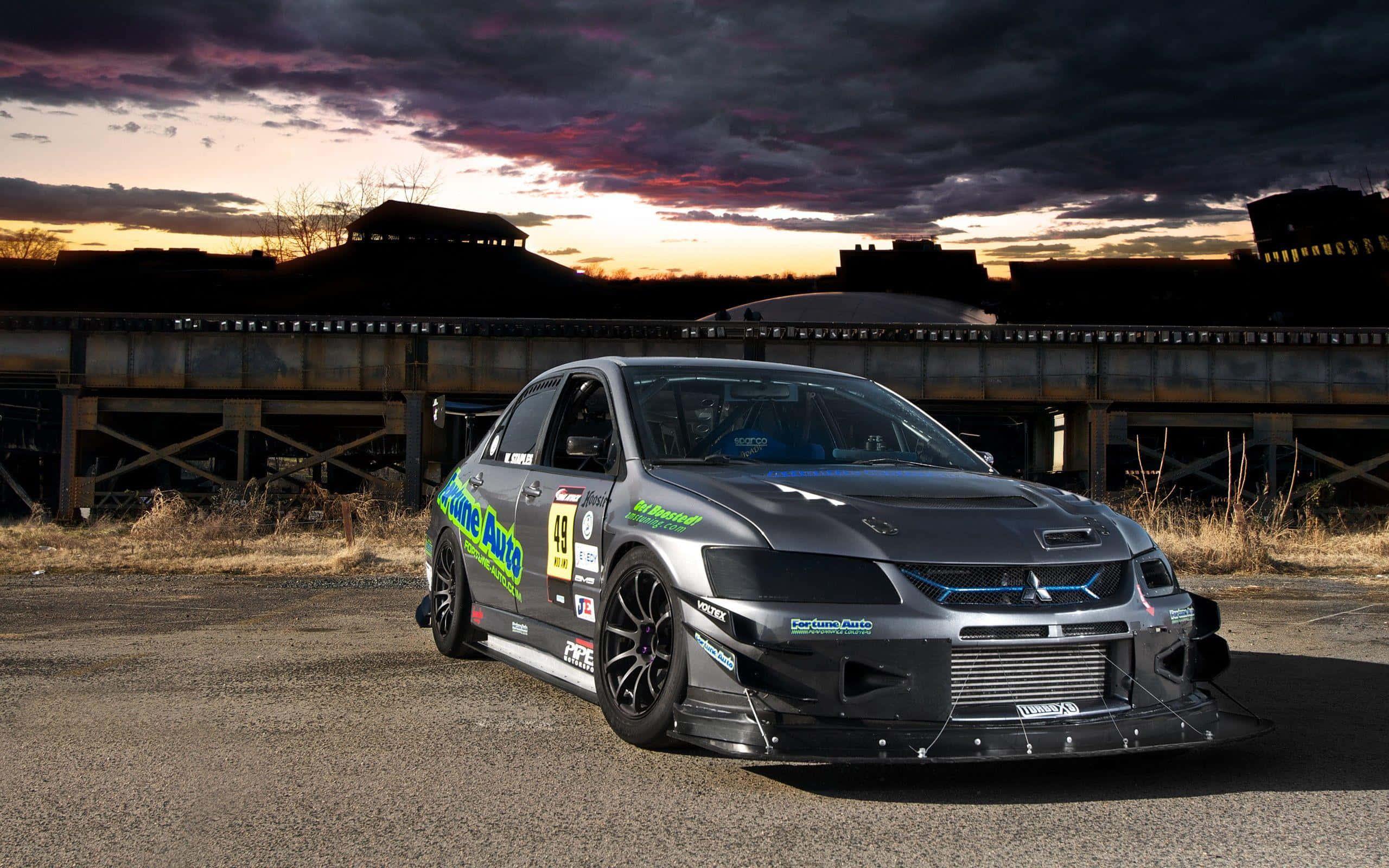 dark gray race car, green decals, twilight sky, 2K Desktop Wallpaper