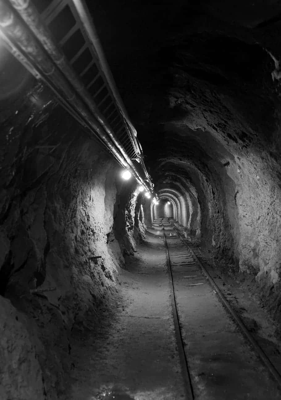 dimly lit mining tunnel, rough stone walls, railway tracks, HD Phone Wallpaper