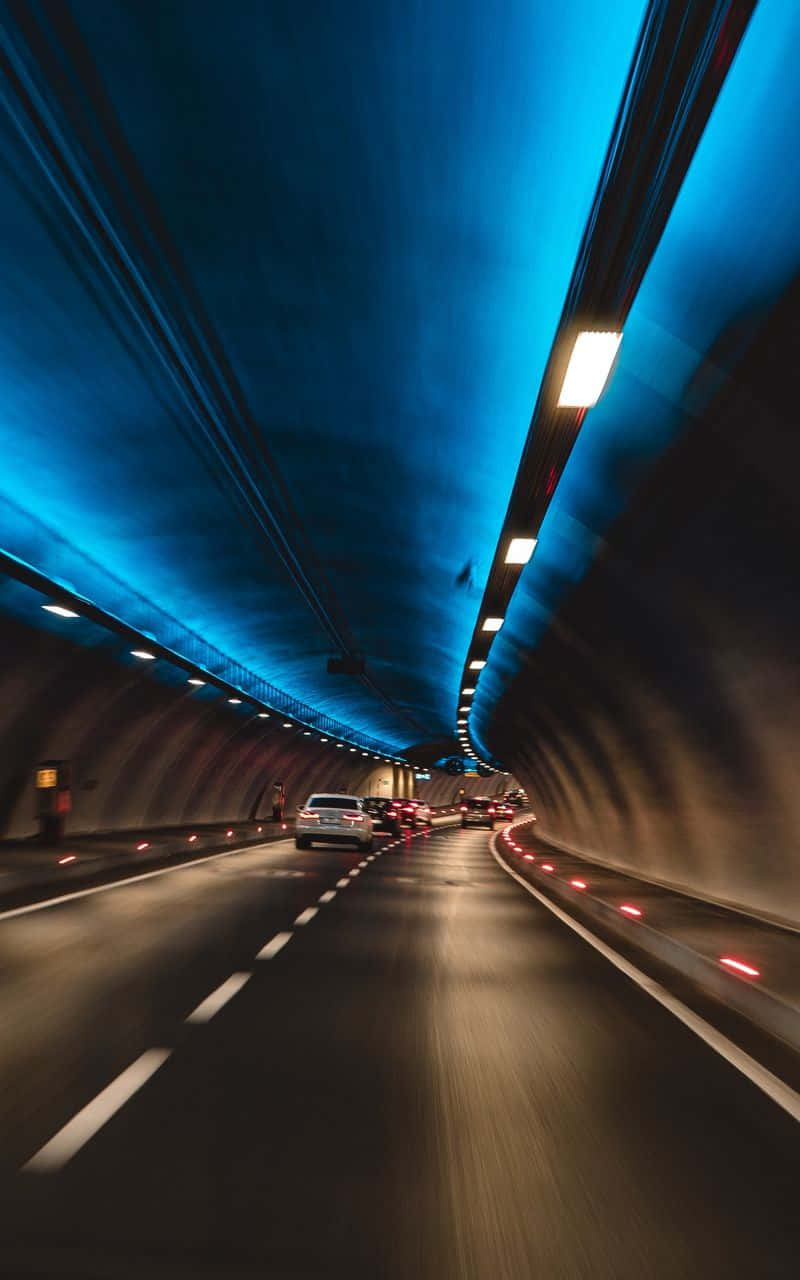illuminated tunnel, vibrant blue lighting, glowing lane markers, HD Phone Wallpaper