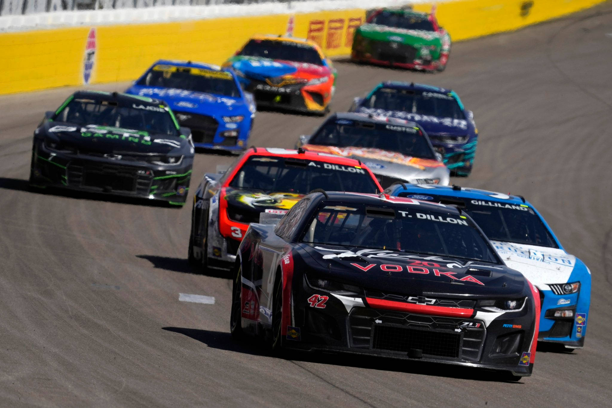 NASCAR race cars, sunlit asphalt turn, yellow walls, Full HD Desktop Wallpaper