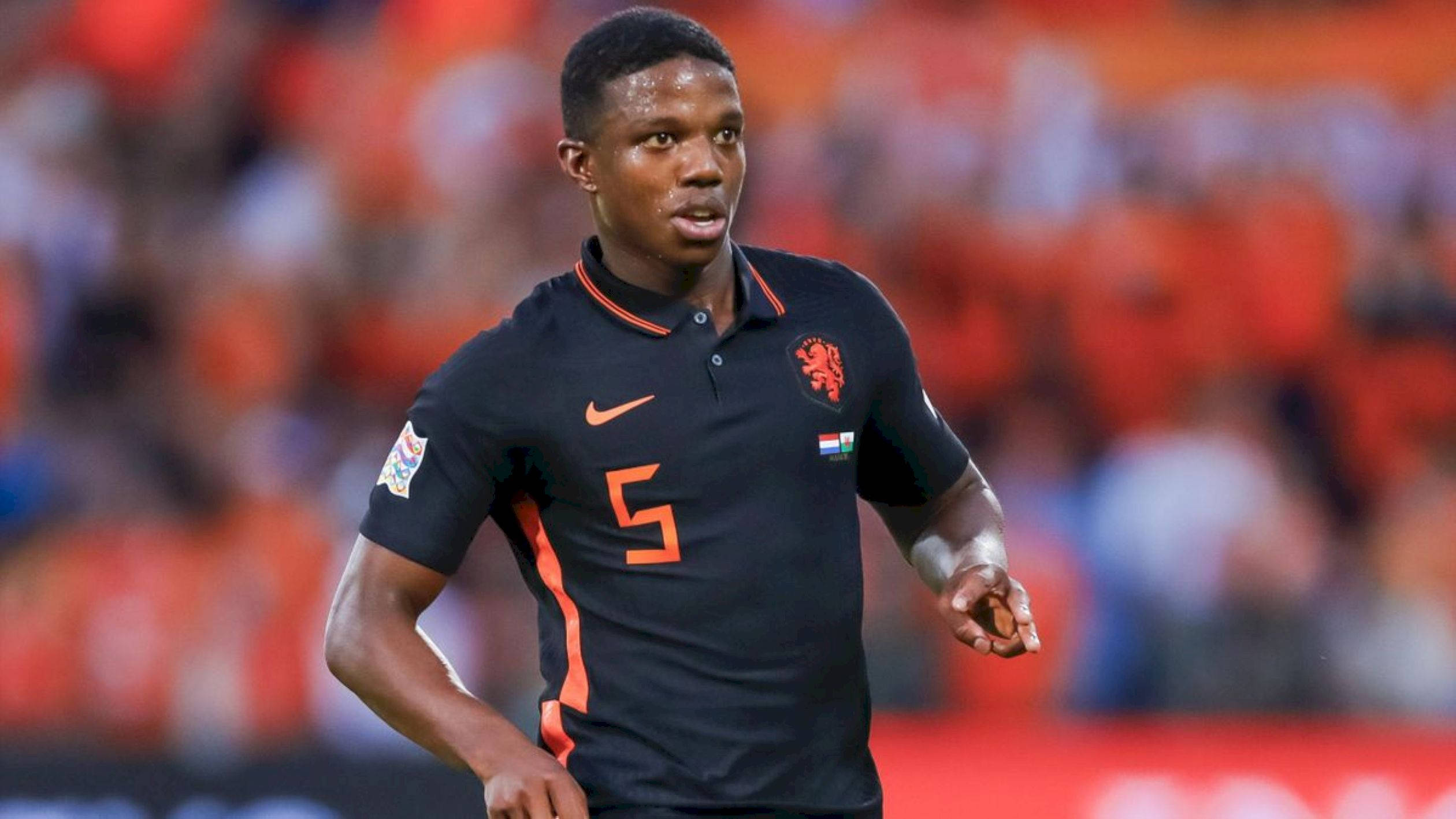 Tyrell Malacia, black and orange jersey, brightly lit field, Full HD Desktop Wallpaper