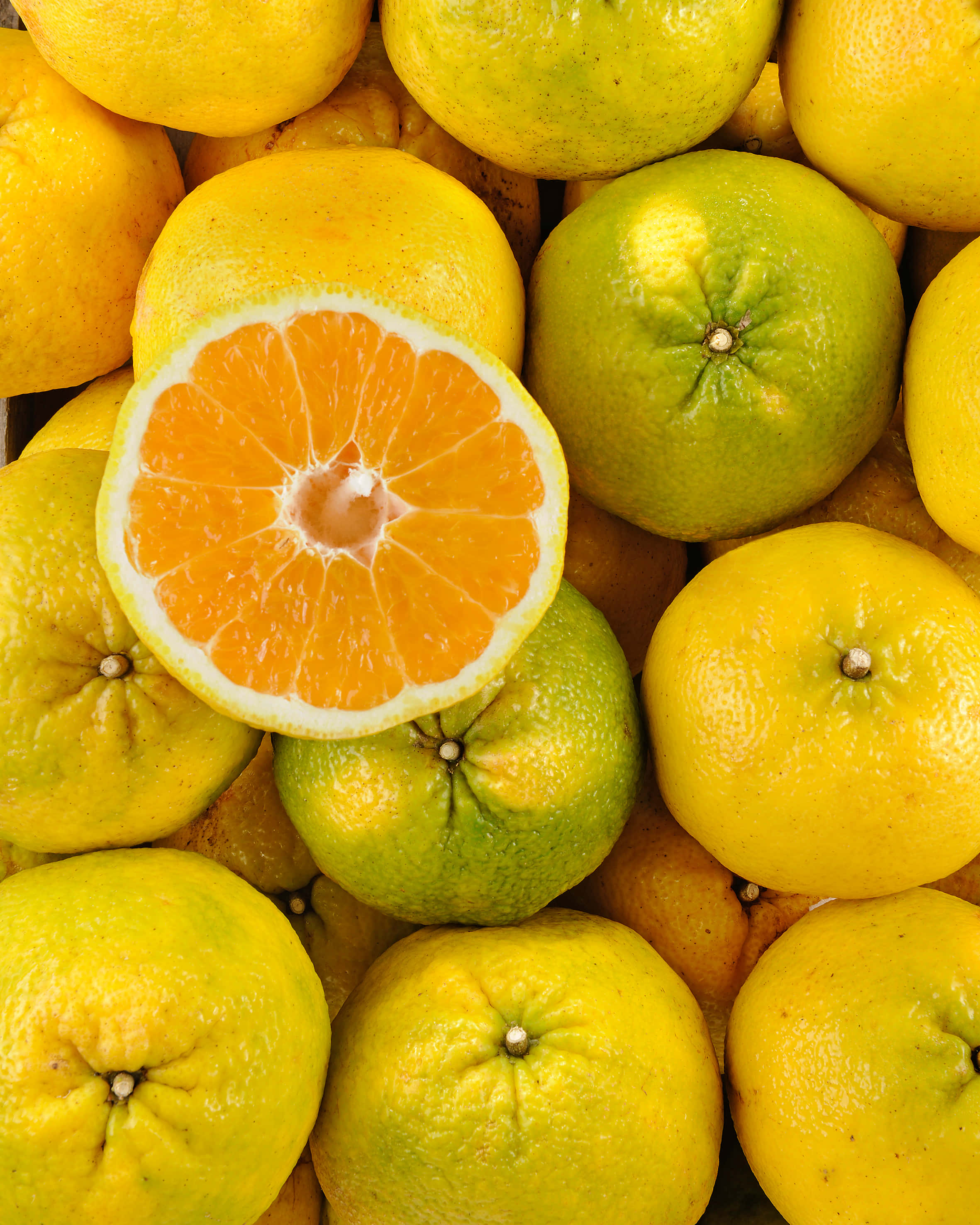 Ugli fruit, whole yellow and green oranges, halved orange, 2K Phone Wallpaper