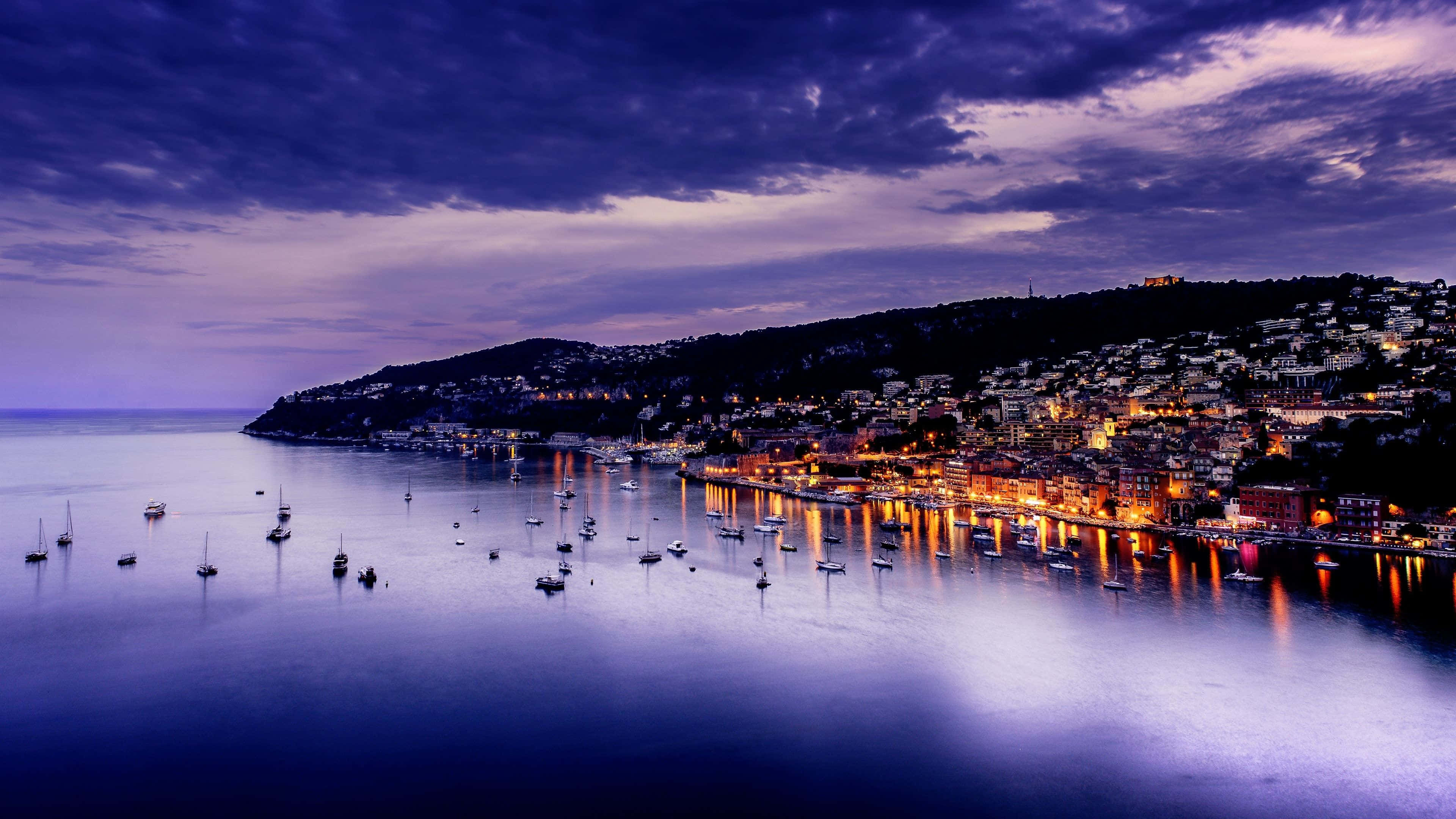 coastal town, warm lights, calm waters, 4K Desktop Wallpaper
