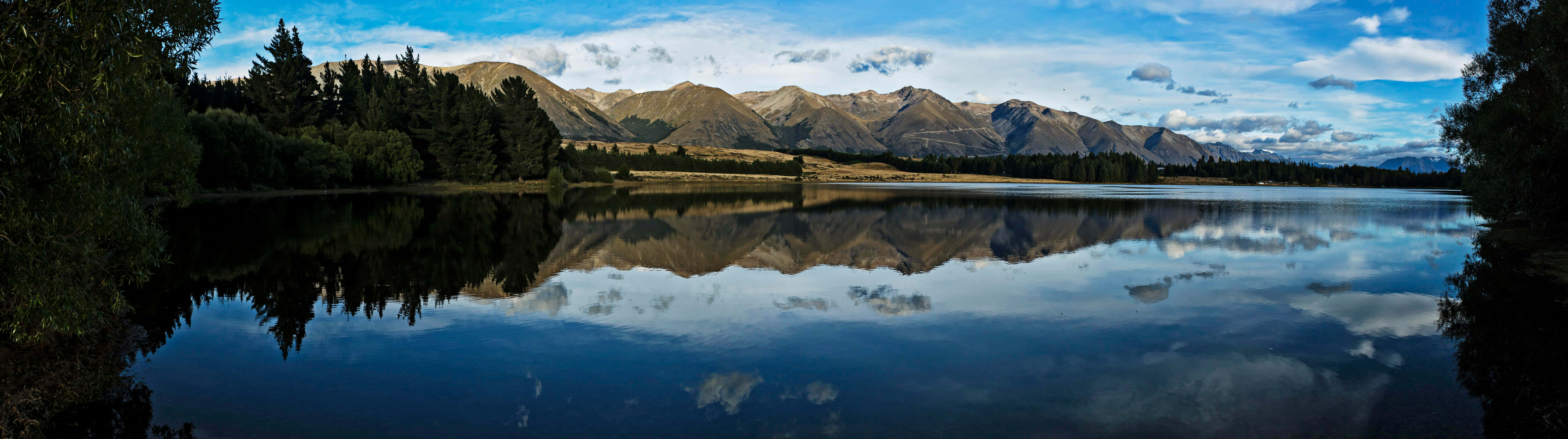 mountain lake, rugged peaks, partly cloudy sky, 8K Desktop Wallpaper