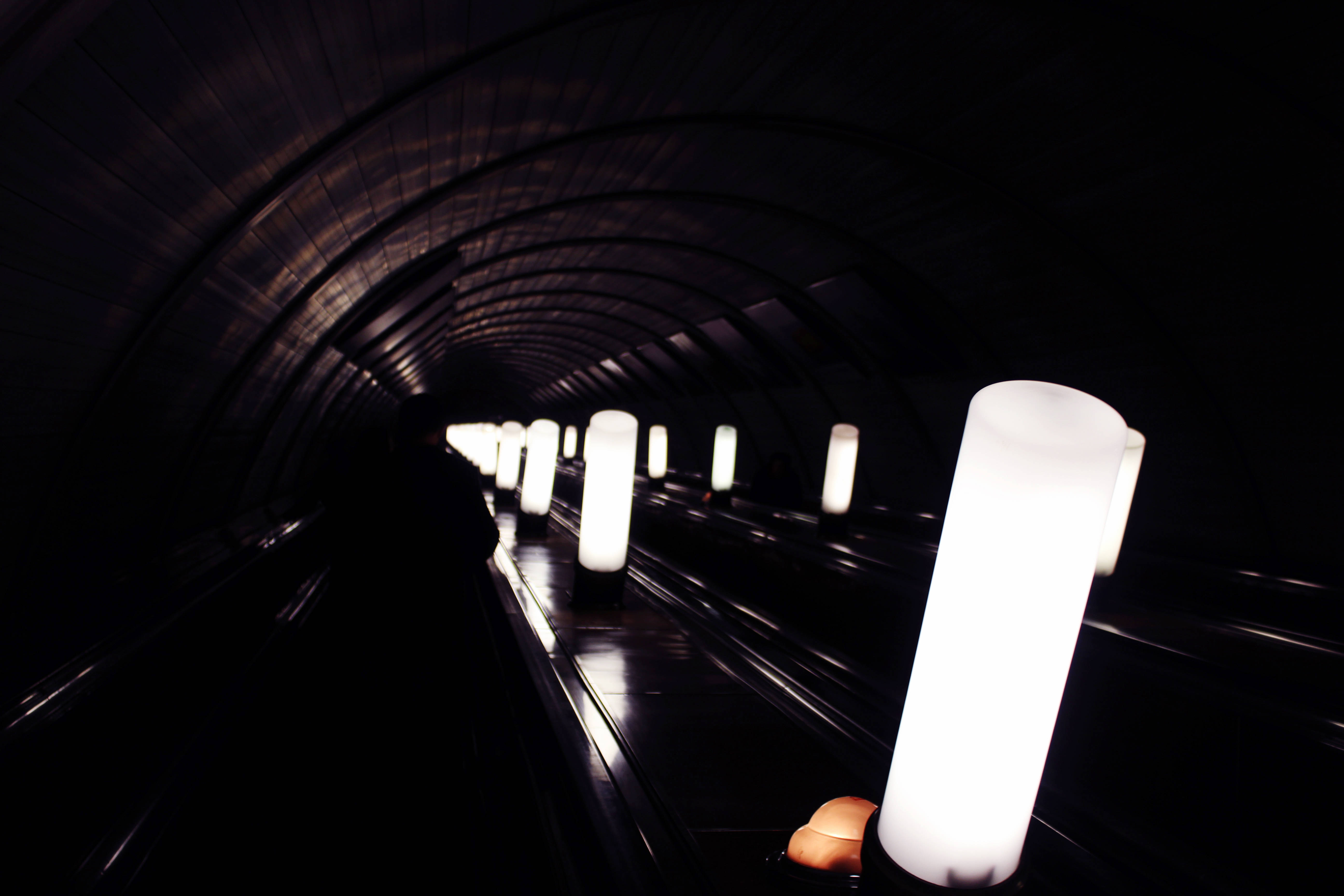 underground subway, glowing white cylindrical lights, dark curved tunnel, 5K Desktop Wallpaper