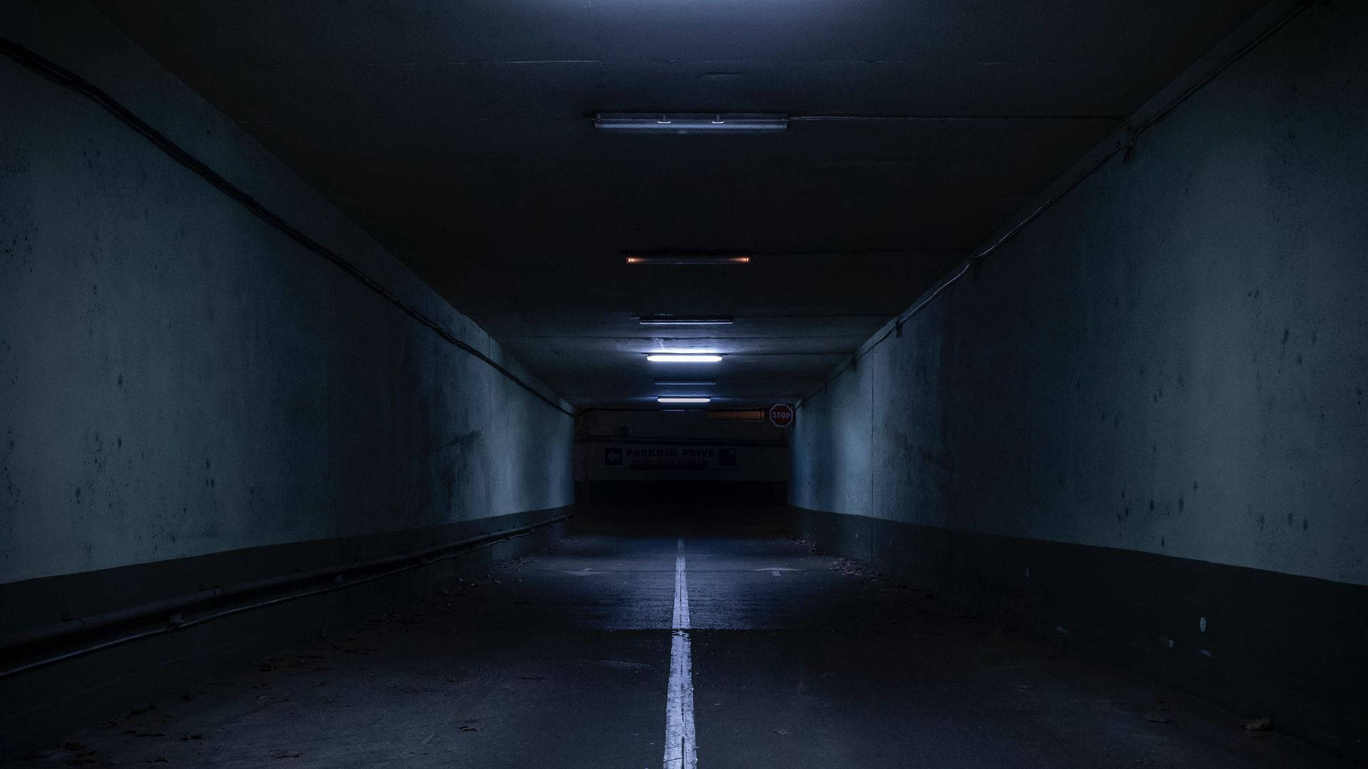 underground parking garage tunnel, white line down the center, flickering fluorescent lights, Full HD Desktop Wallpaper