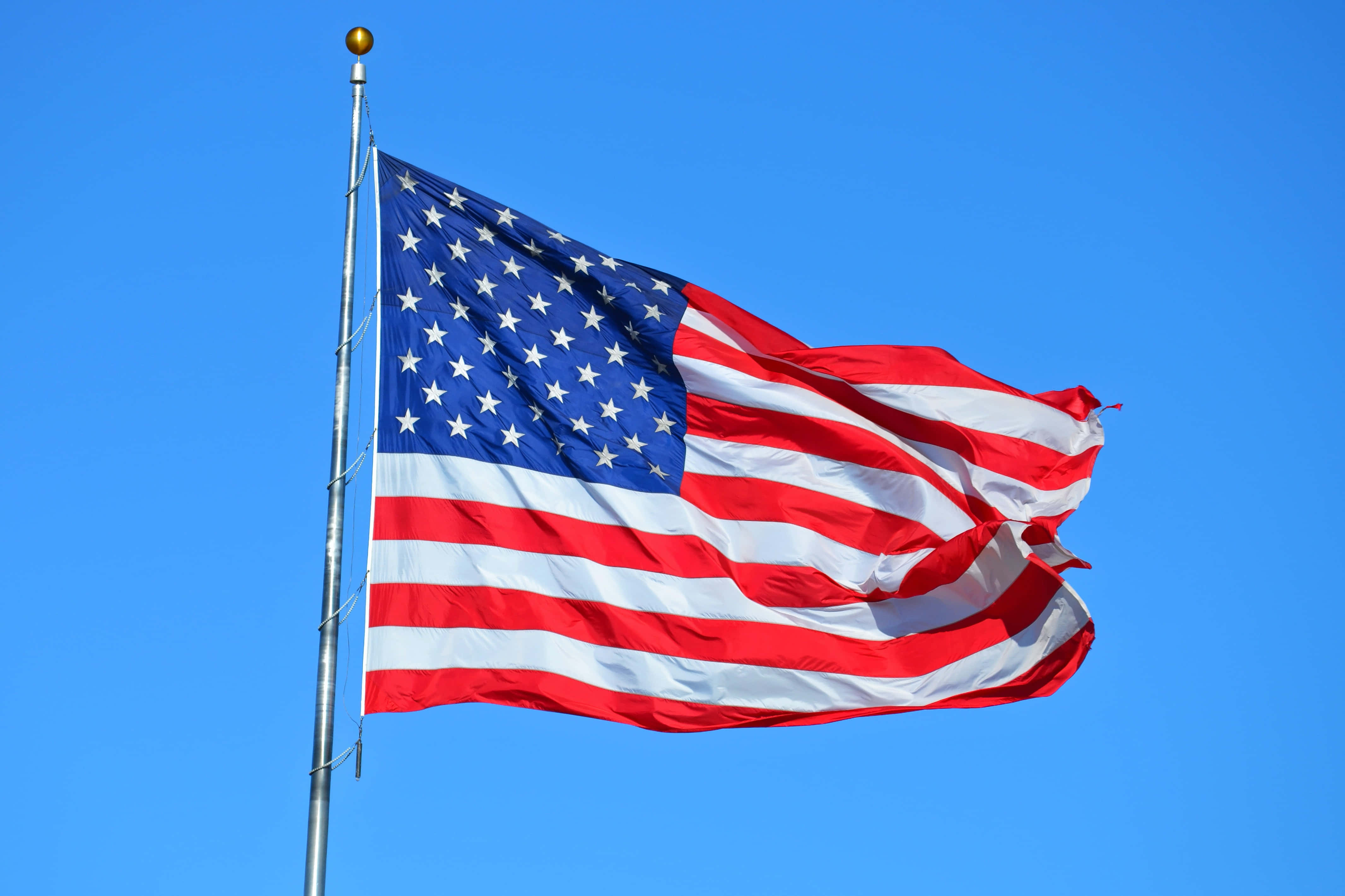 U.S. Flag, clear blue sky, bold red white and blue colors, 4K Desktop Wallpaper